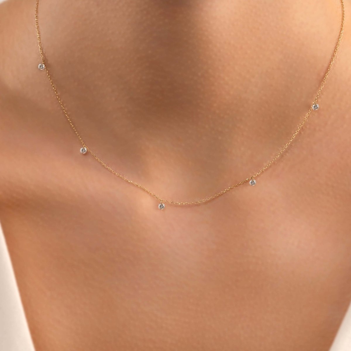 A 14k gold chain necklace with drilled diamonds, displayed on a mannequin.
