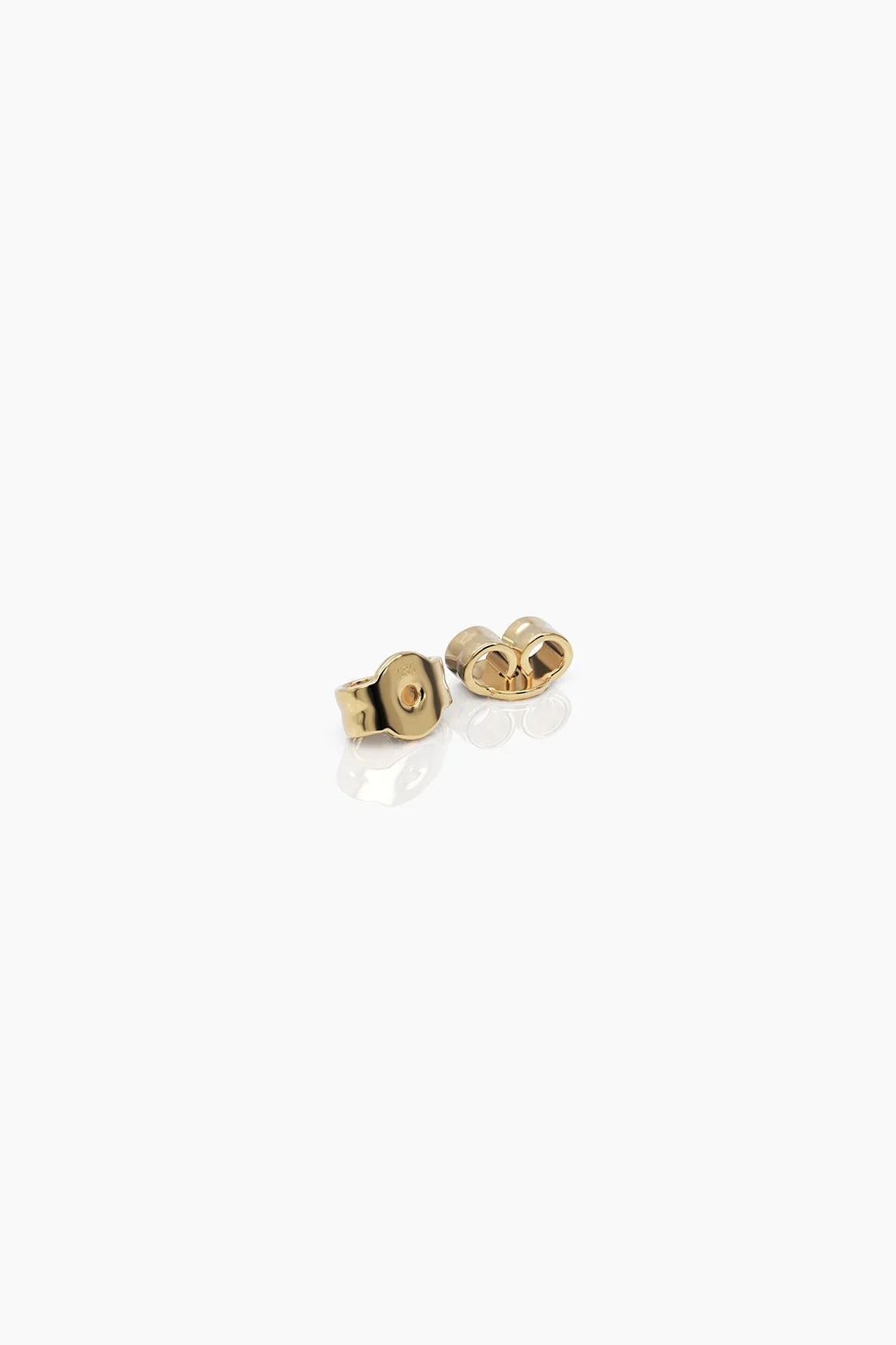 Pair of yellow gold matching butterfly backs, placed on a white surface