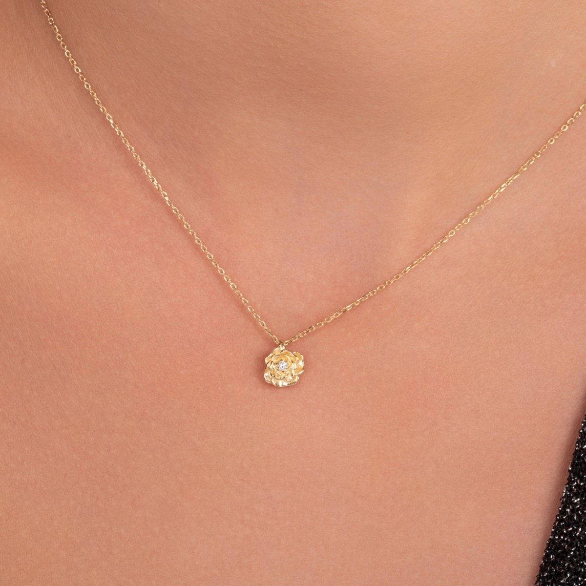 Close-up of the diamond rose necklace worn around the neck, styled with a minimal 14k yellow gold chain.