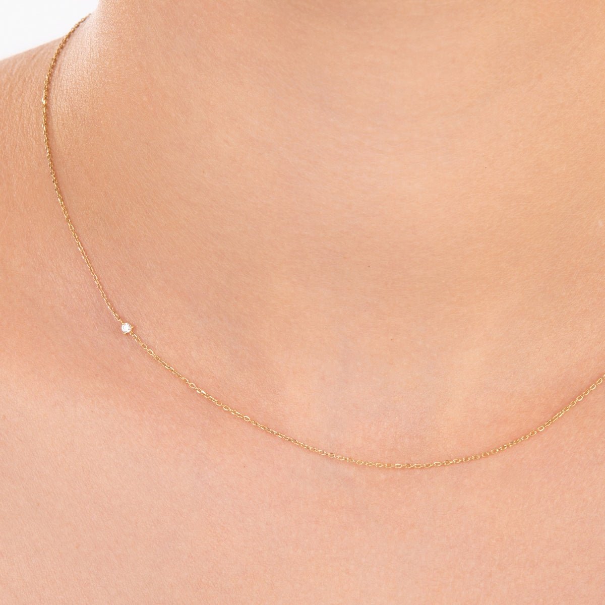 Model wearing the diamond choker with the diamond placed slightly off-center, showing the adjustable fit of the 14k gold chain.