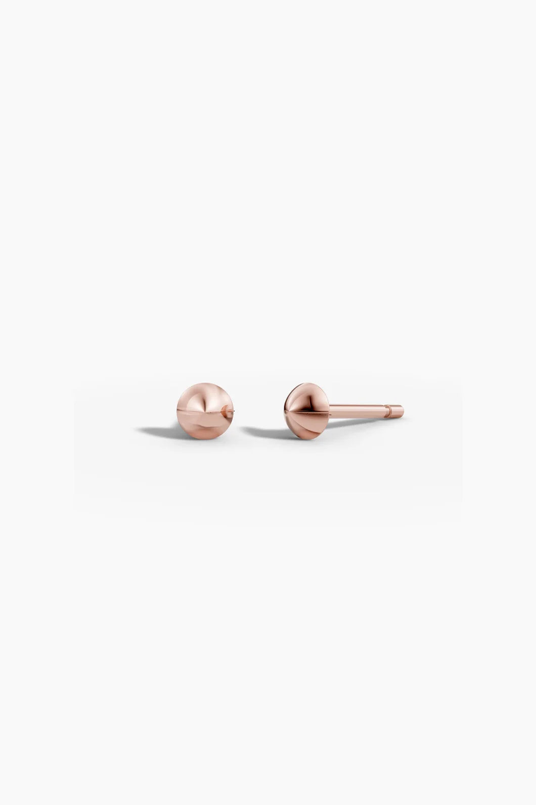 Pair of point studs in rose gold, side-by-side, highlighting their soft pink tone and rounded shape.