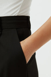 14k gold beaded chain bracelet styled on wrist, paired with tailored black trousers, minimalist everyday jewelry by ENEA