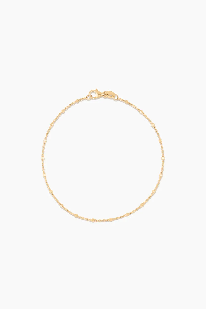 Close-up of 14k solid gold bracelet with polished bead details, laid flat with clasp visible