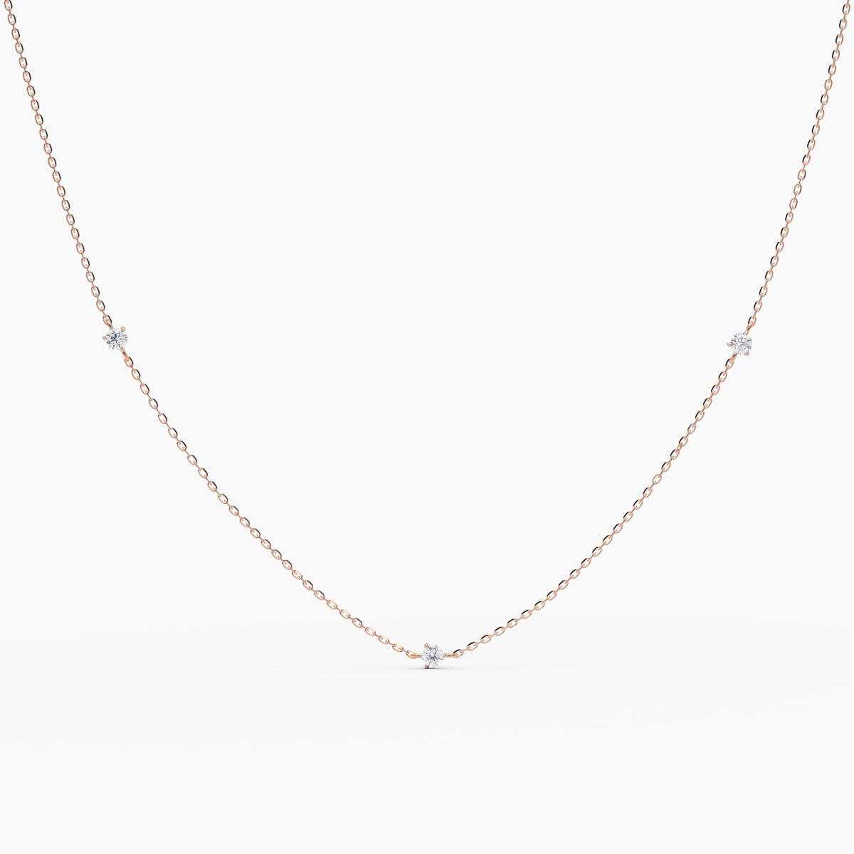 14k rose gold necklace with five small round diamonds evenly spaced along a delicate chain, shown on white background
