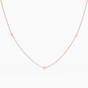 14k rose gold necklace with five small round diamonds evenly spaced along a delicate chain, shown on white background