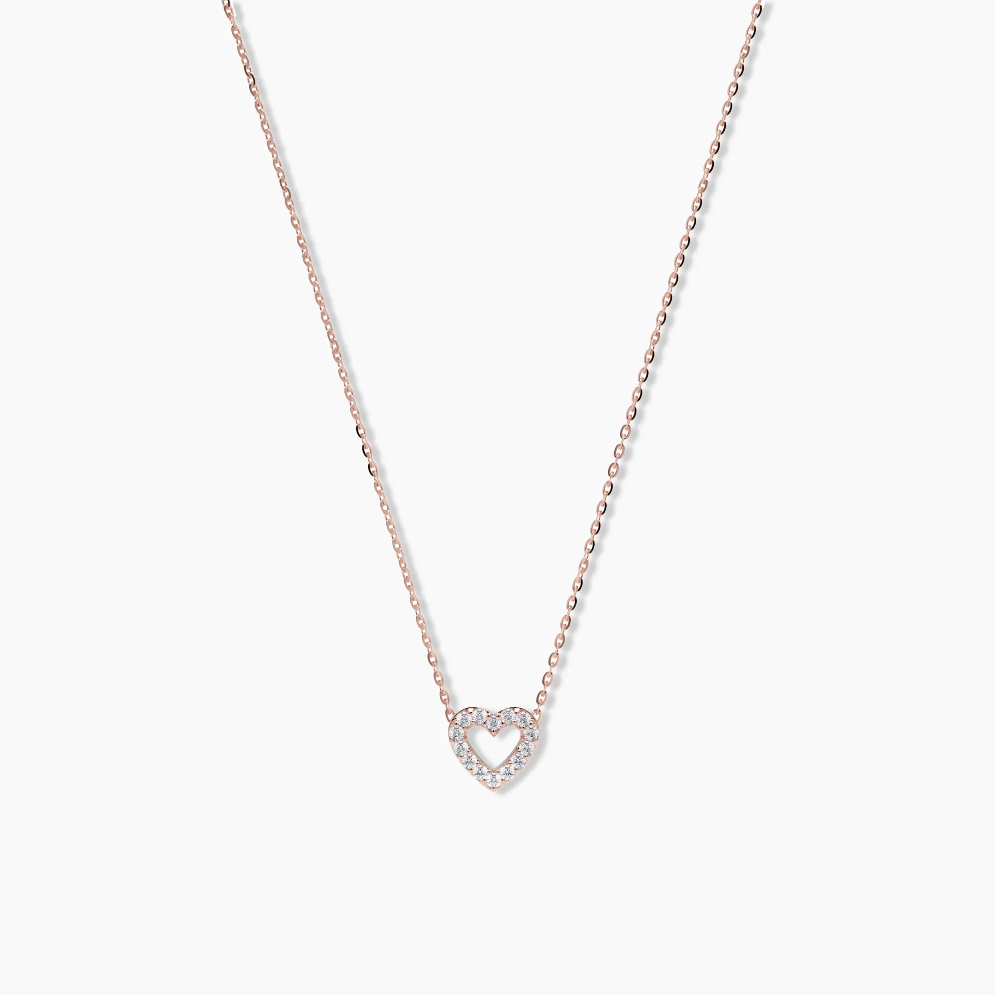Rose gold pavé diamond heart necklace with open center, displayed against a clean white background to highlight its soft blush tone and fine detailing.