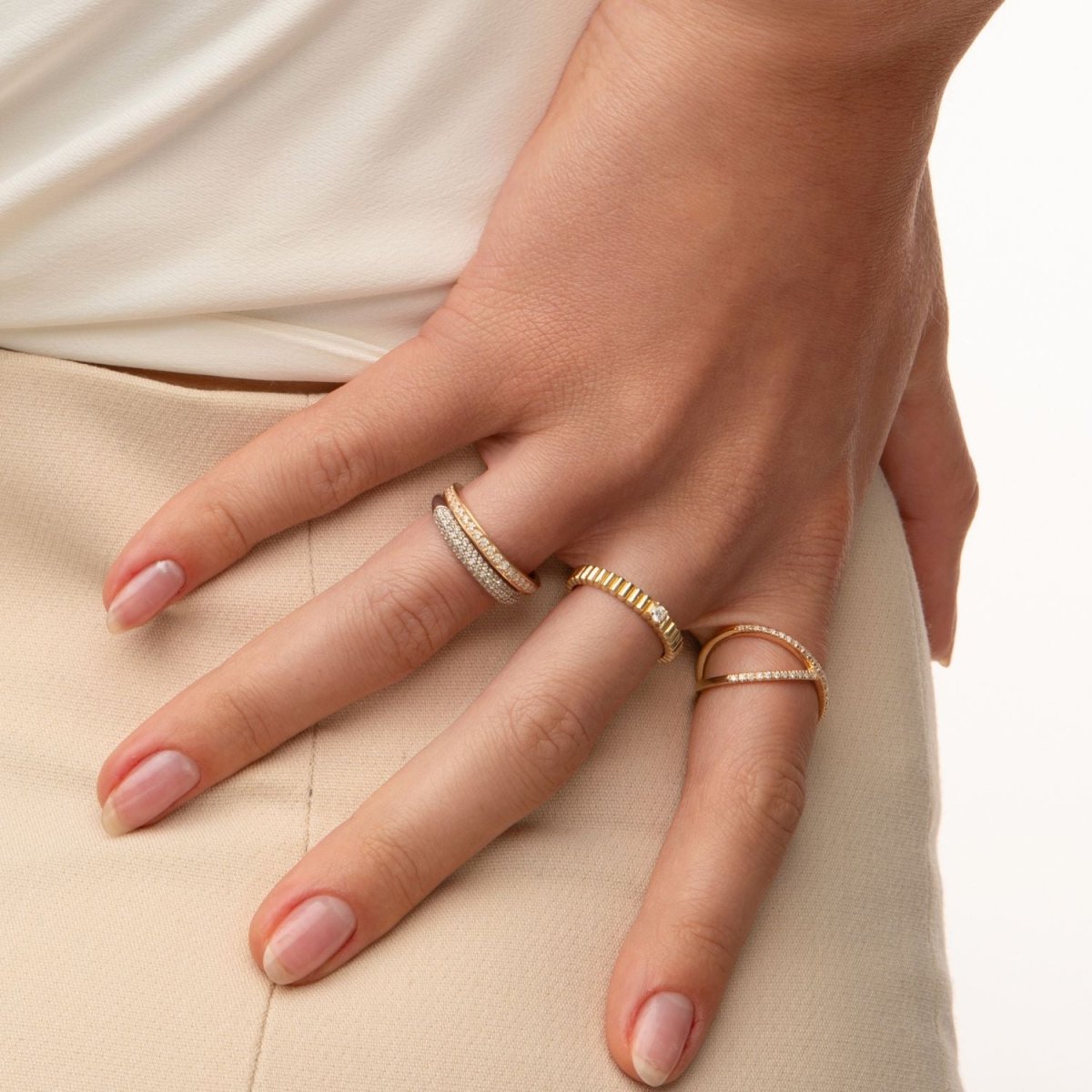 A trendy jewelry stack featuring the ribbed gold ring with other fine rings for layering inspiration.