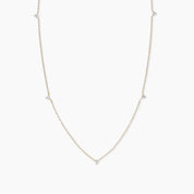 Yellow gold necklace featuring five evenly spaced round diamonds along a fine chain, displayed against a white background.