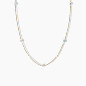 Minimalist yellow gold necklace with evenly spaced round diamonds set along a delicate cable chain, displayed on a white background.