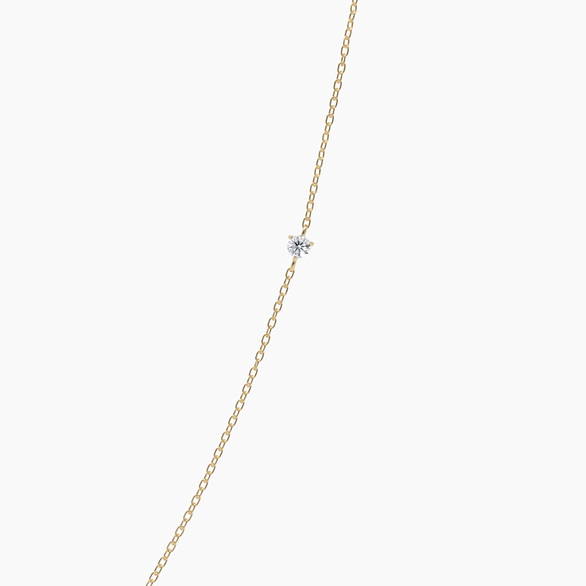 Product close-up of the necklace against a white background, focusing on the center diamond and fine 14k yellow gold chain.