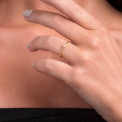 A close-up of a baguette diamond ring in yellow gold, showcasing its modern elegance.