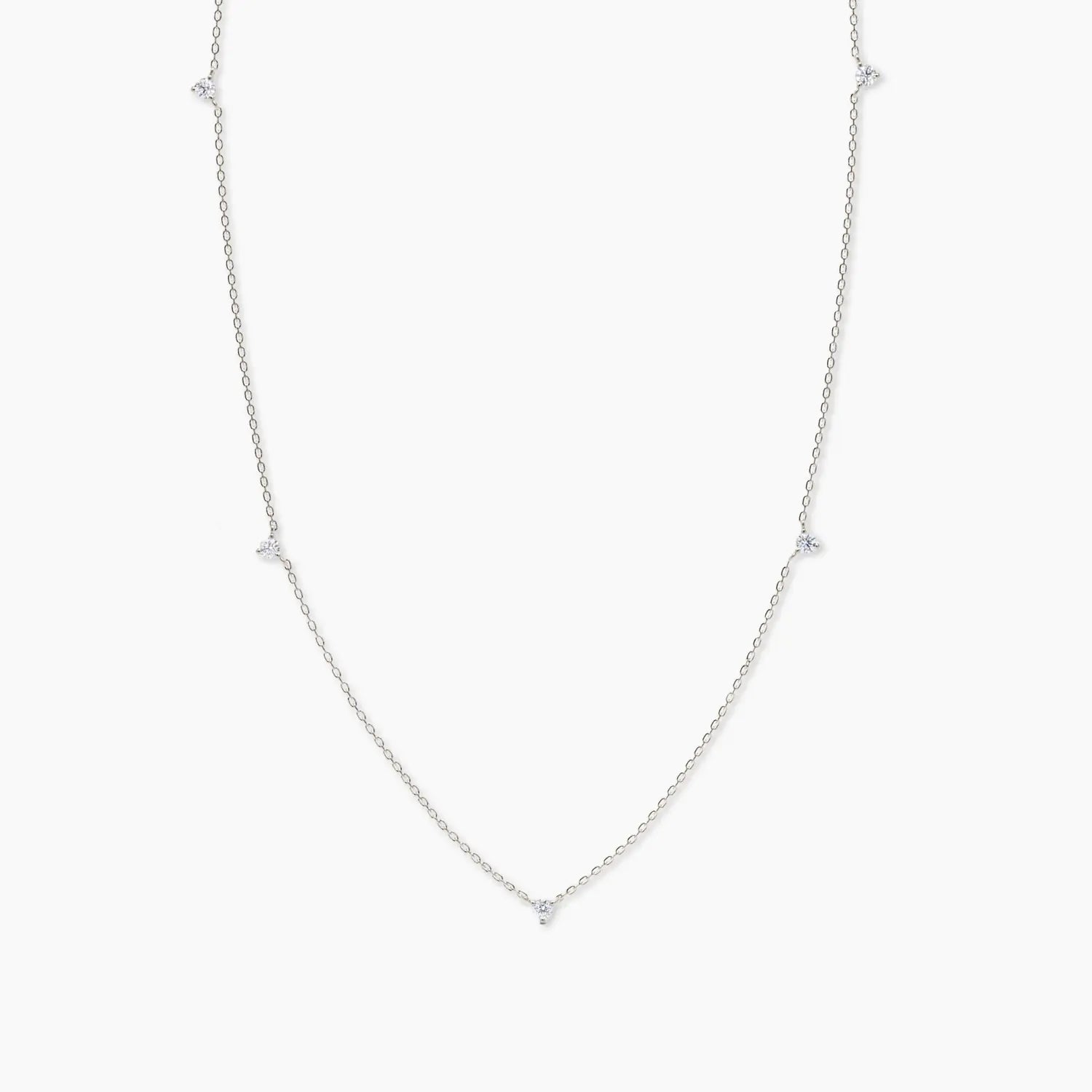White gold necklace with five small white diamonds evenly spaced along a delicate chain, shown on a plain white background.