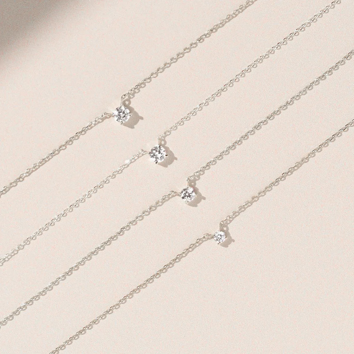 14k white gold diamond solitaire necklaces in different carat sizes side by side