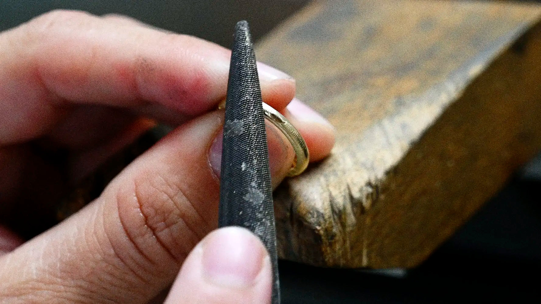 ENEA Studio goldsmith working a solid gold piece at the bench in the Athens workshop
