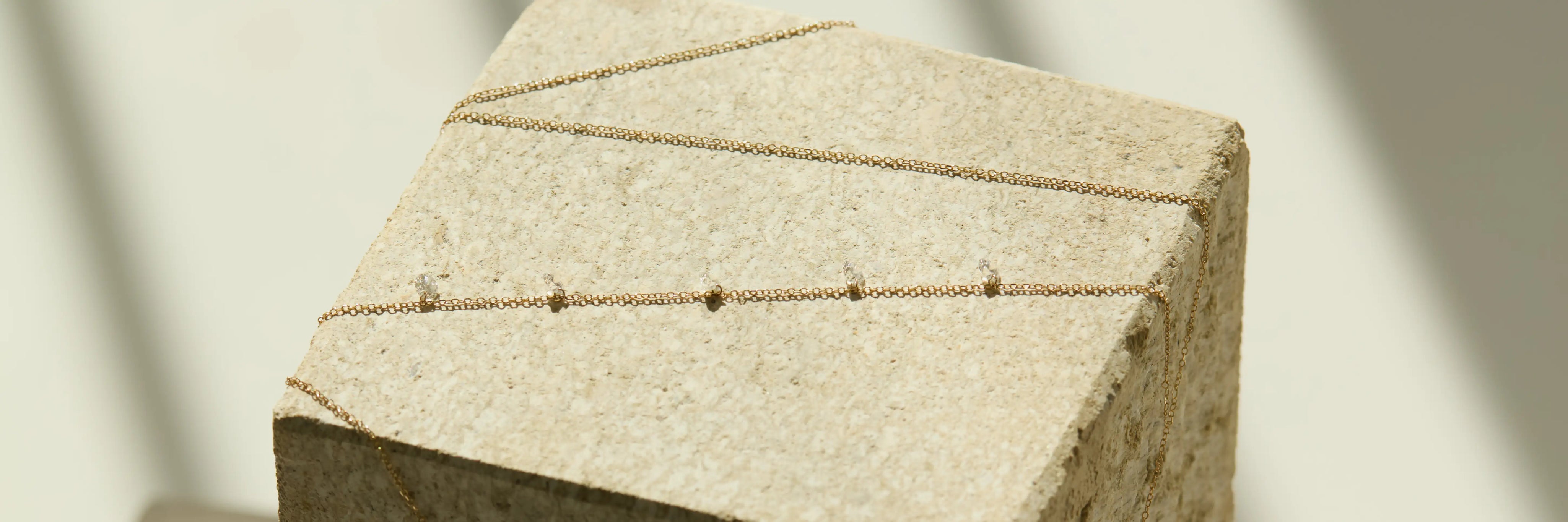 ENEA Nema Collection dainty solid 14k gold necklaces on neutral background