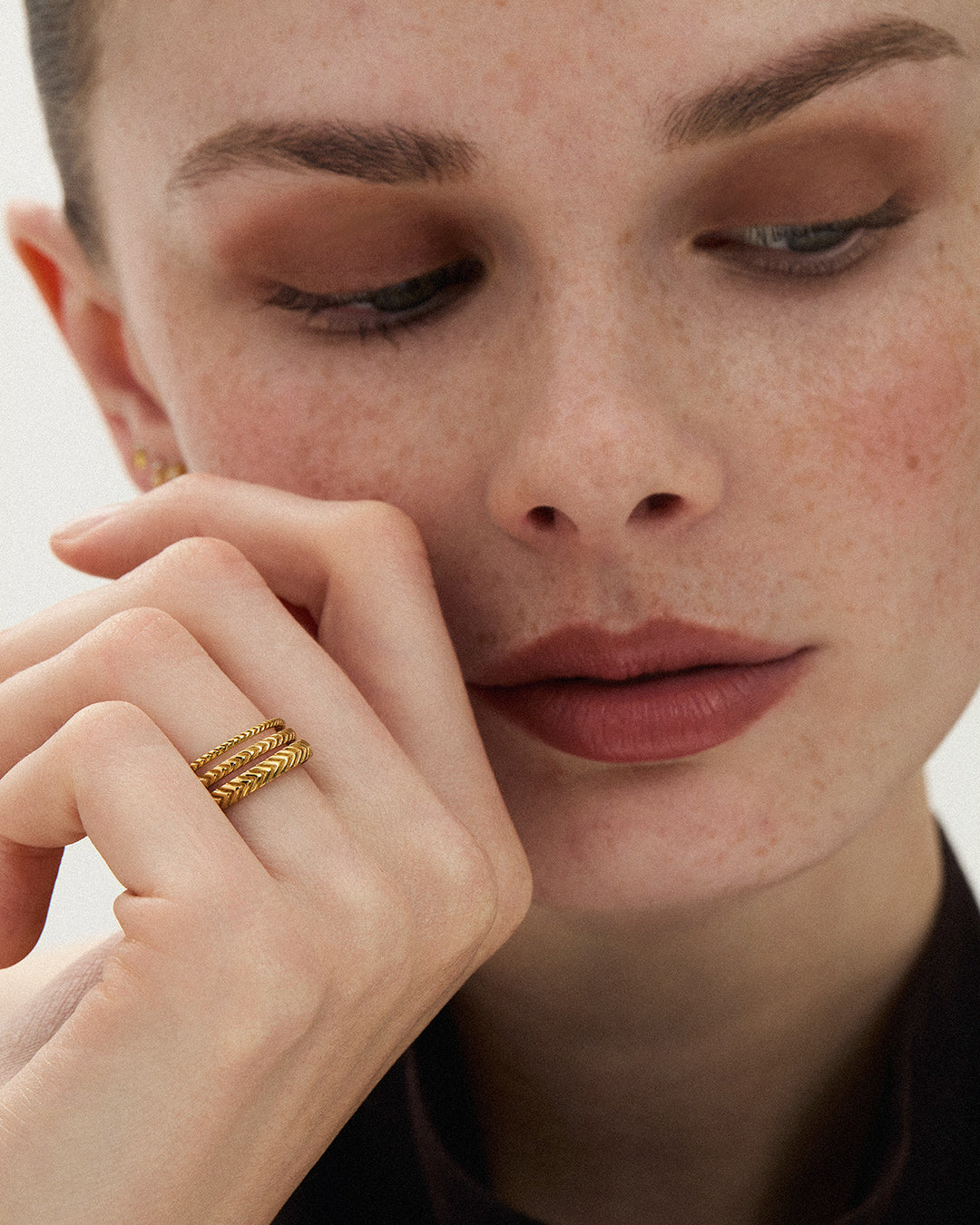 Close up of the Lefkandi Chevron Ring stack in 14k yellow gold on the model's hand, ENEA Studio