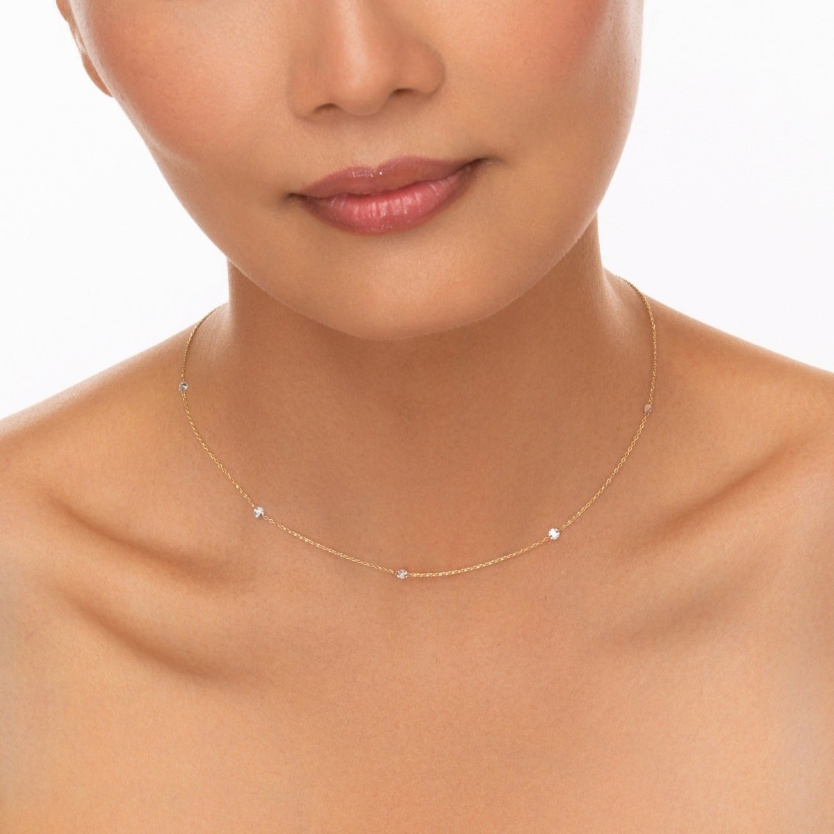 Model wears the dainty yellow gold necklace, showcasing how the diamonds sit along the collarbone in natural light.

