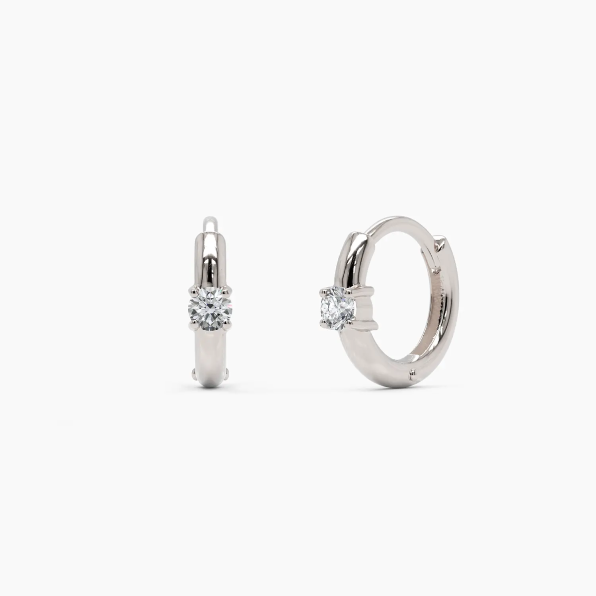 14k white gold diamond huggie hoop earrings with a refined, polished finish and a round brilliant diamond accent. A timeless and sophisticated earring set.