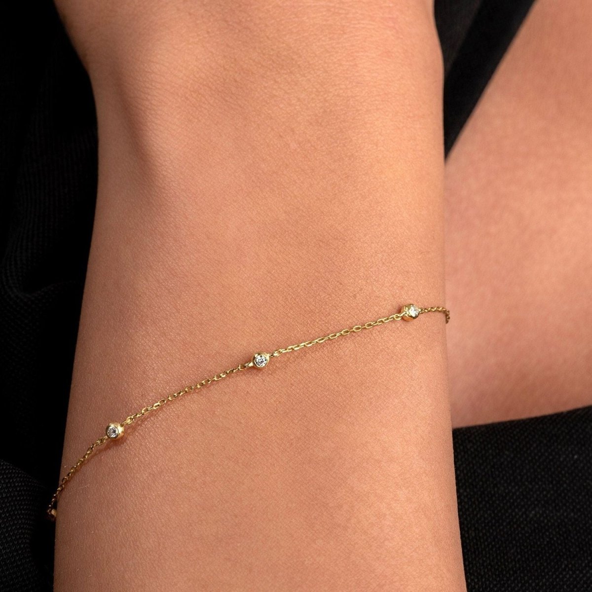 Subtle and elegant, the diamond bracelet contrasts against the model’s black sleeve for a refined styling moment.


