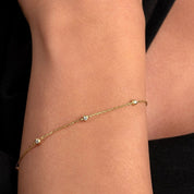 Subtle and elegant, the diamond bracelet contrasts against the model’s black sleeve for a refined styling moment.

