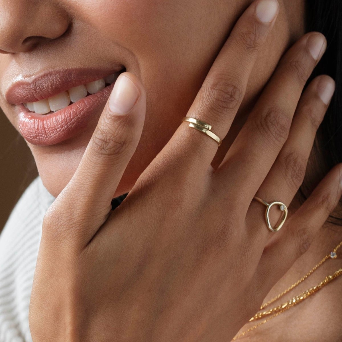 model wearing the yellow gold dainty spiral ring, stacked with other delicate bands, highlighting its elegant and versatile styling options

