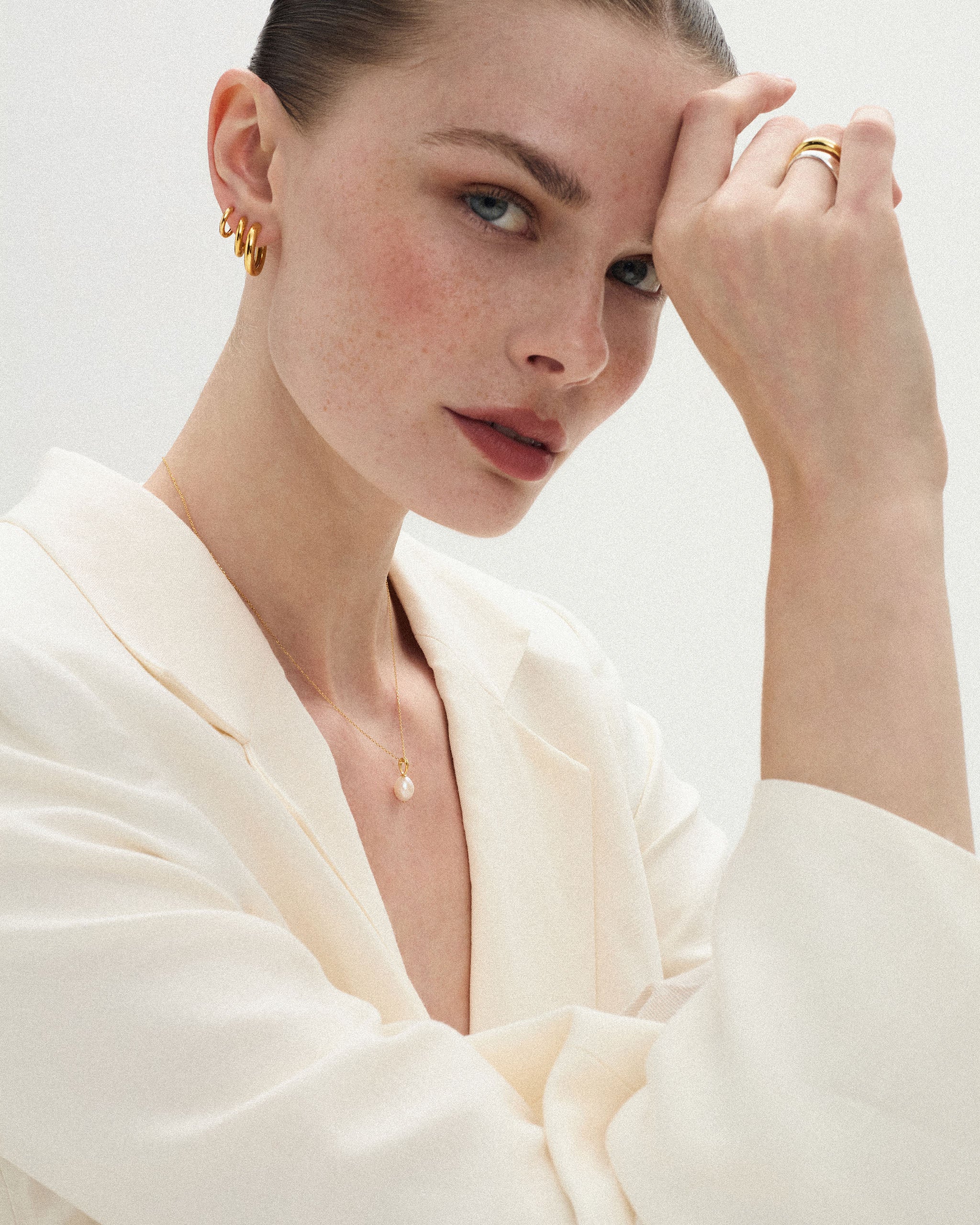 Woman wearing a pearl drop necklace on a fine 14k gold cable chain