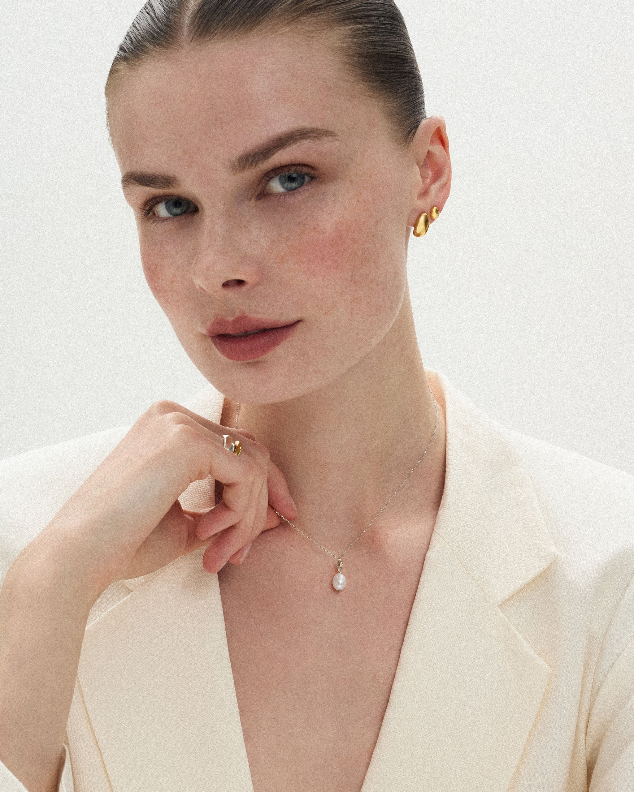 Pearl pendant necklace layered over a plain neckline