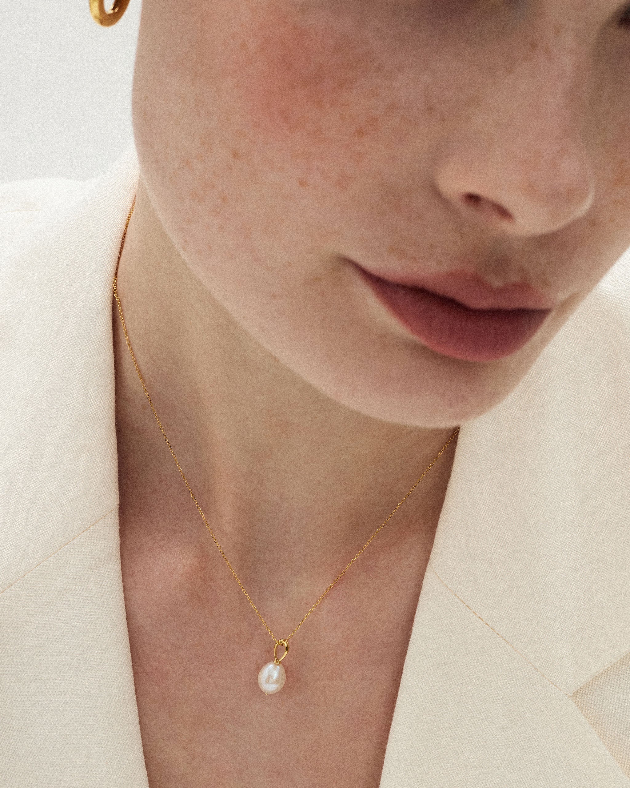 Close up of a single pearl necklace with a one of a kind baroque freshwater pearl