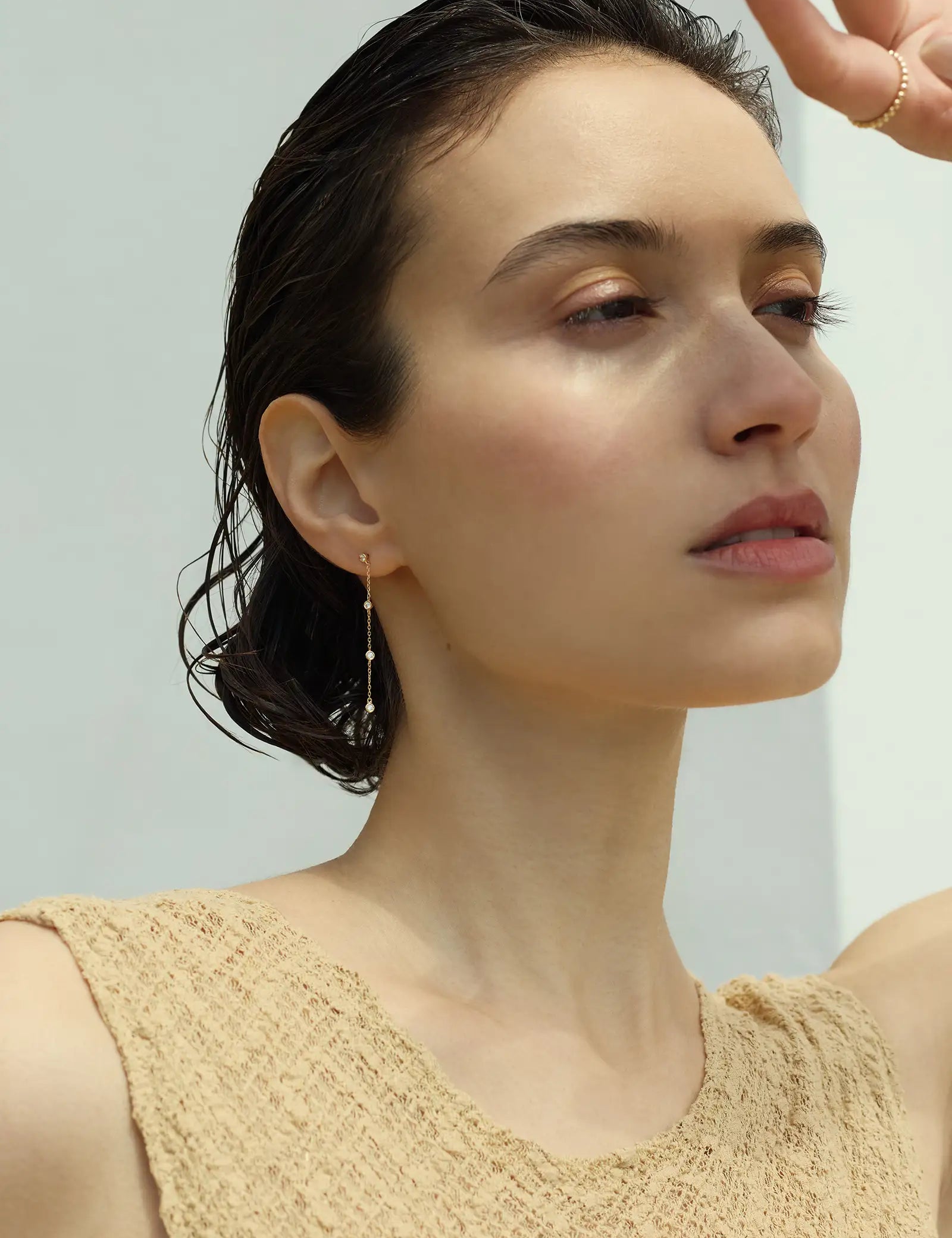solid gold cascade diamond drop earrings on model editorial portrait with bezel set diamonds on chain