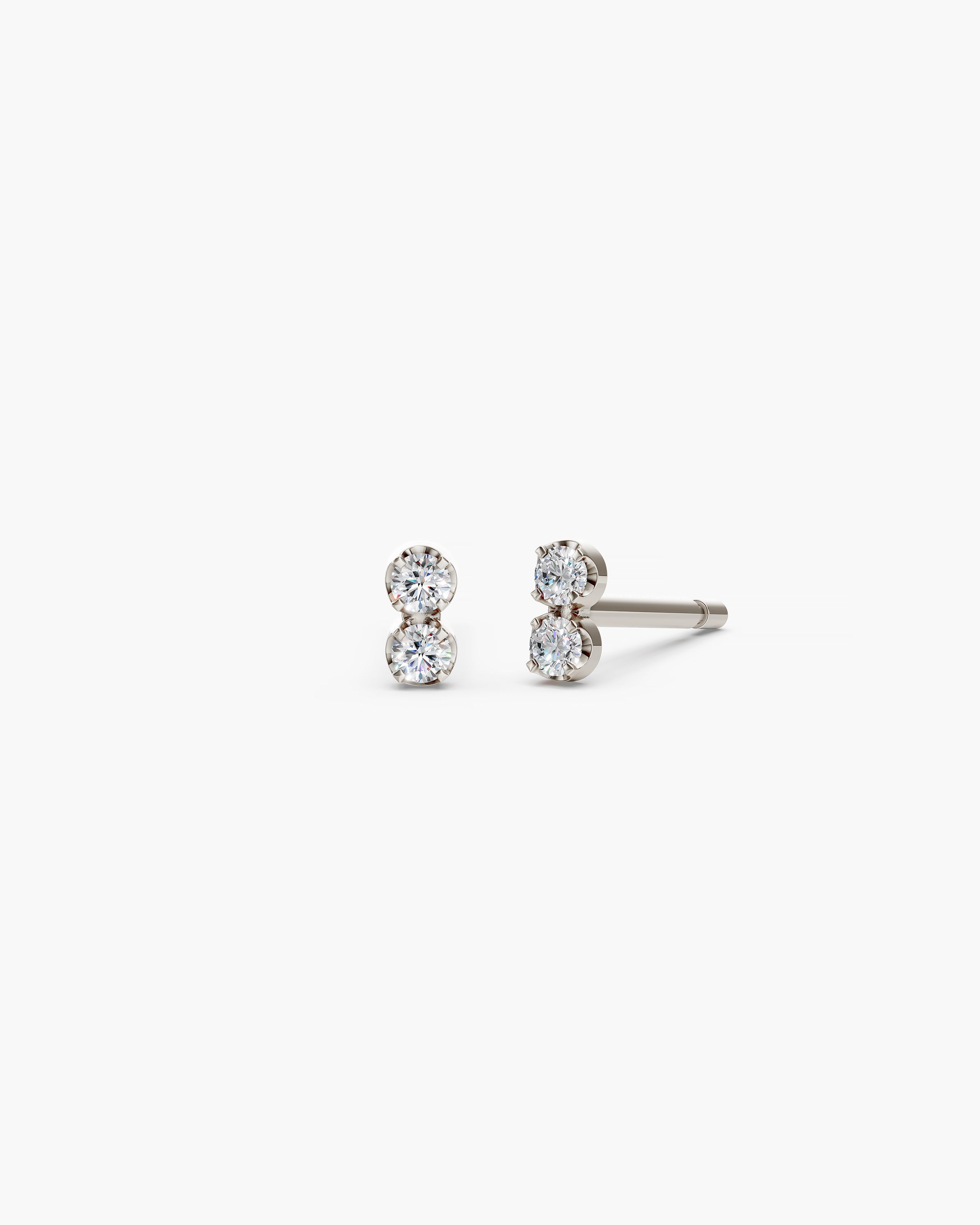 A pair of white gold stud earrings with two round-cut clear gemstones set side-by-side, shown against a plain white background.