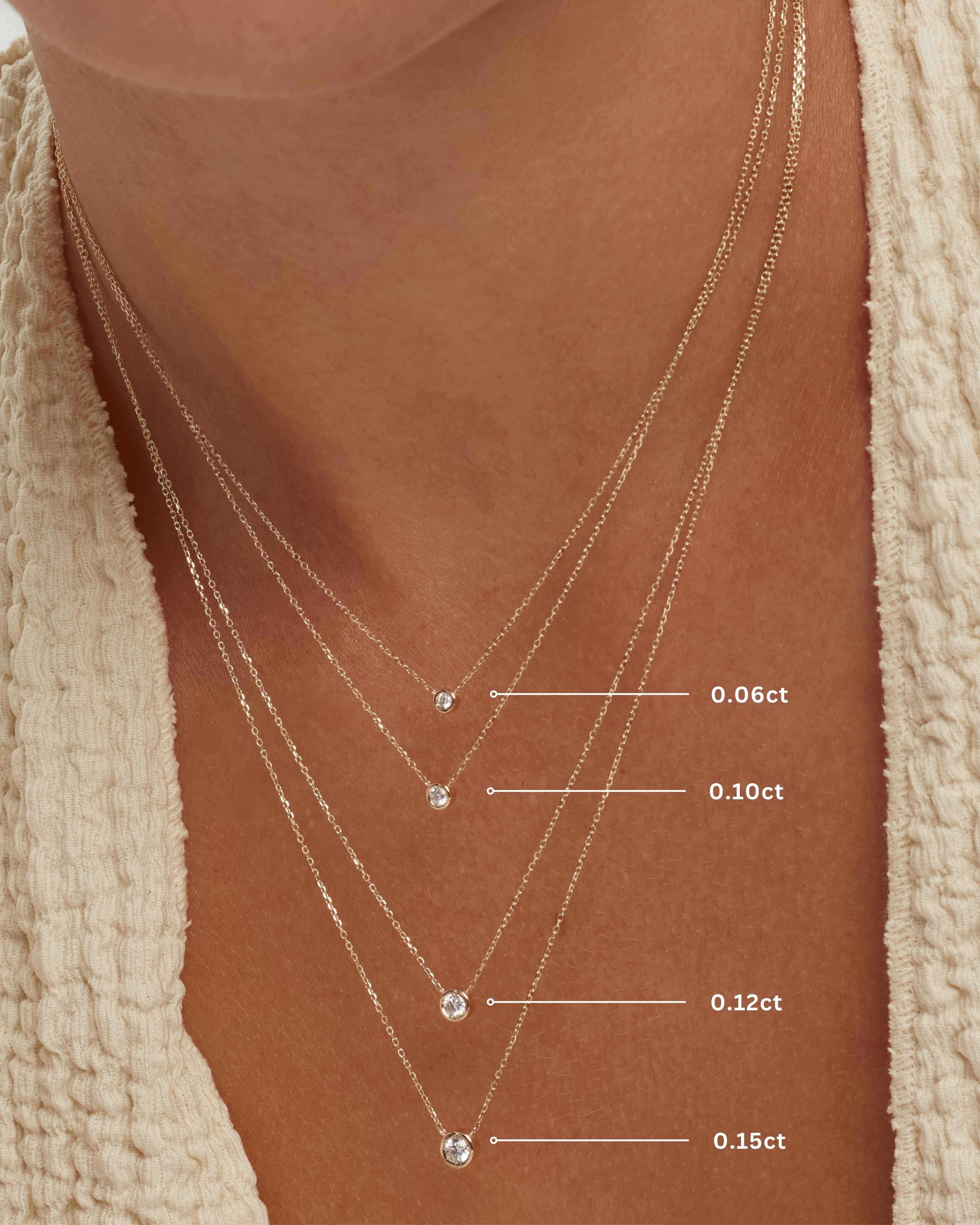 solid gold diamond bezel solitaire necklace size comparison on model showing 0.06ct 0.10ct 0.12ct and 0.15ct diamond options