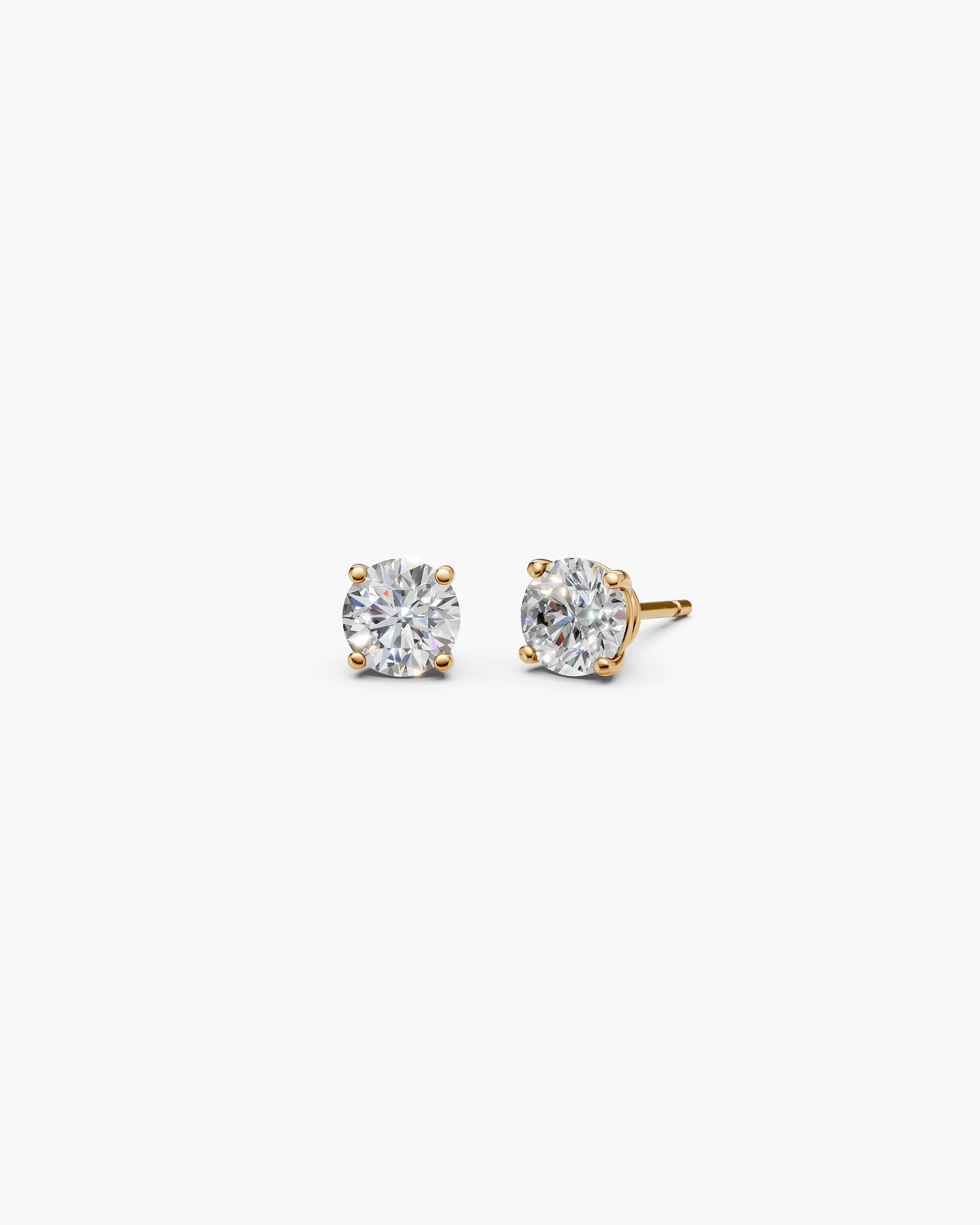 Eclat Grand Diamond Stud Earrings in 14k yellow gold on an off-white surface, front view