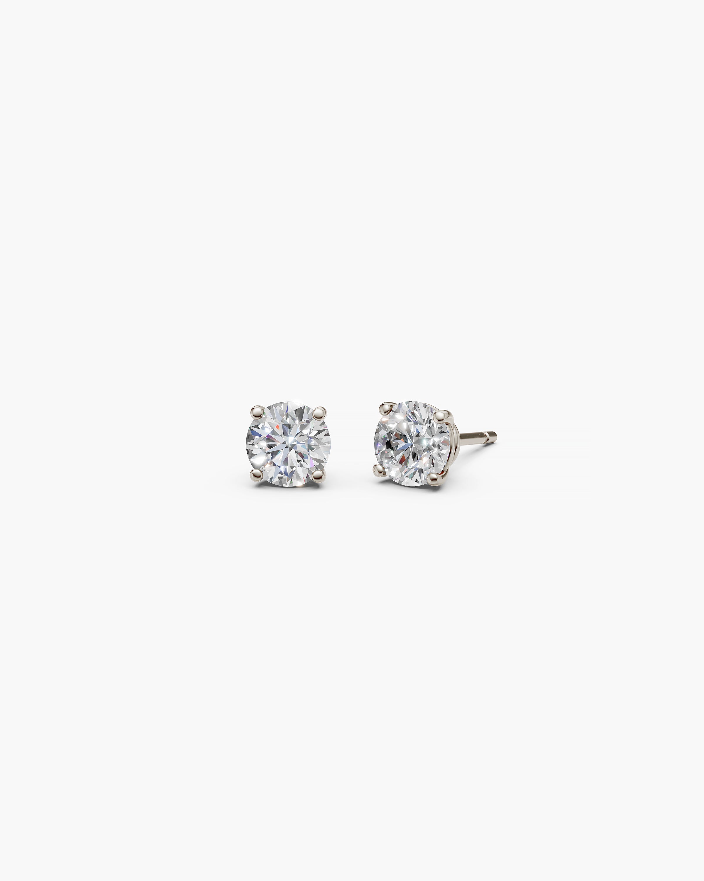 Eclat Grand Diamond Stud Earrings in 14k white gold on an off-white surface, front view