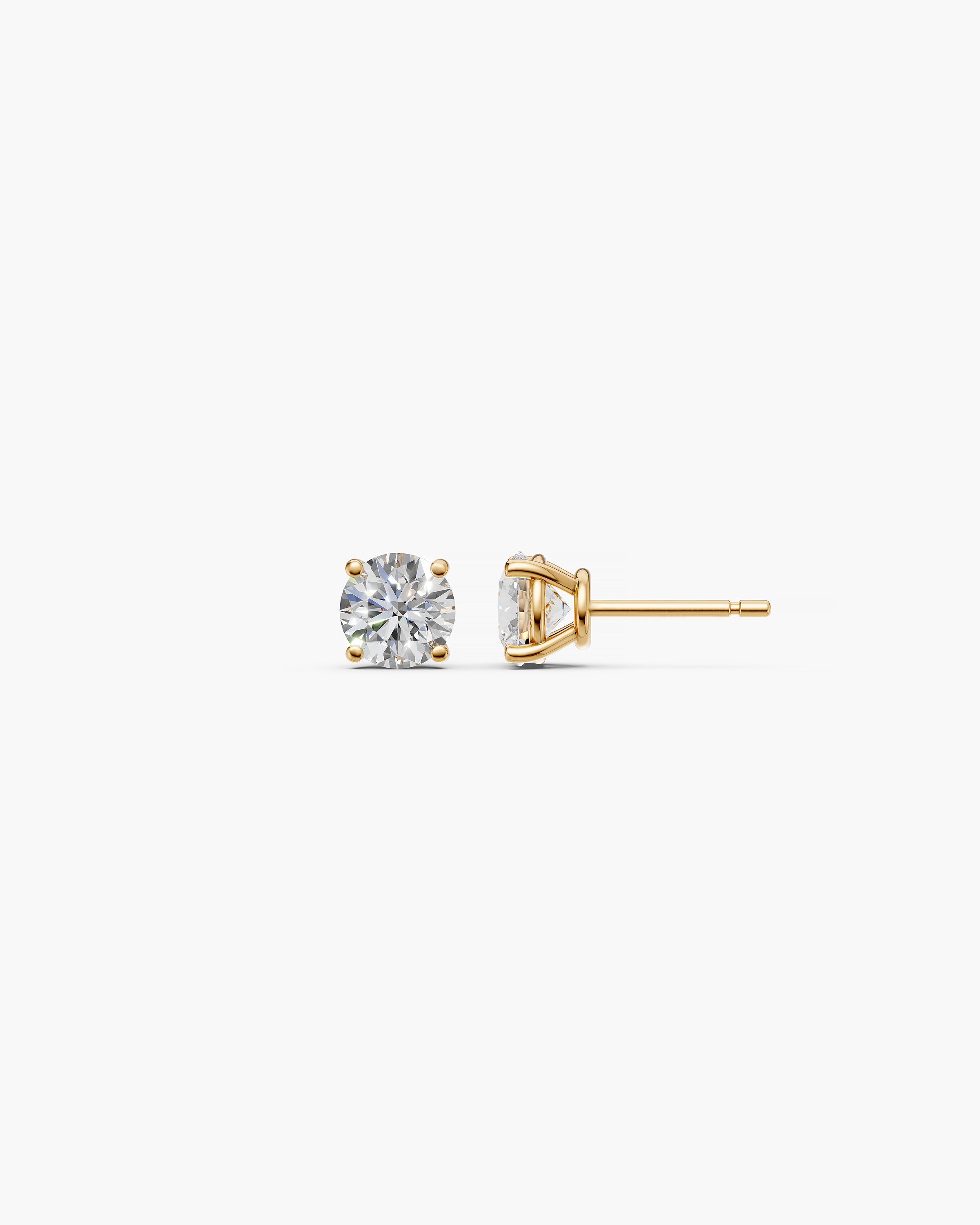 Eclat Grand Diamond Stud Earrings in 14k yellow gold on an off-white surface, side view