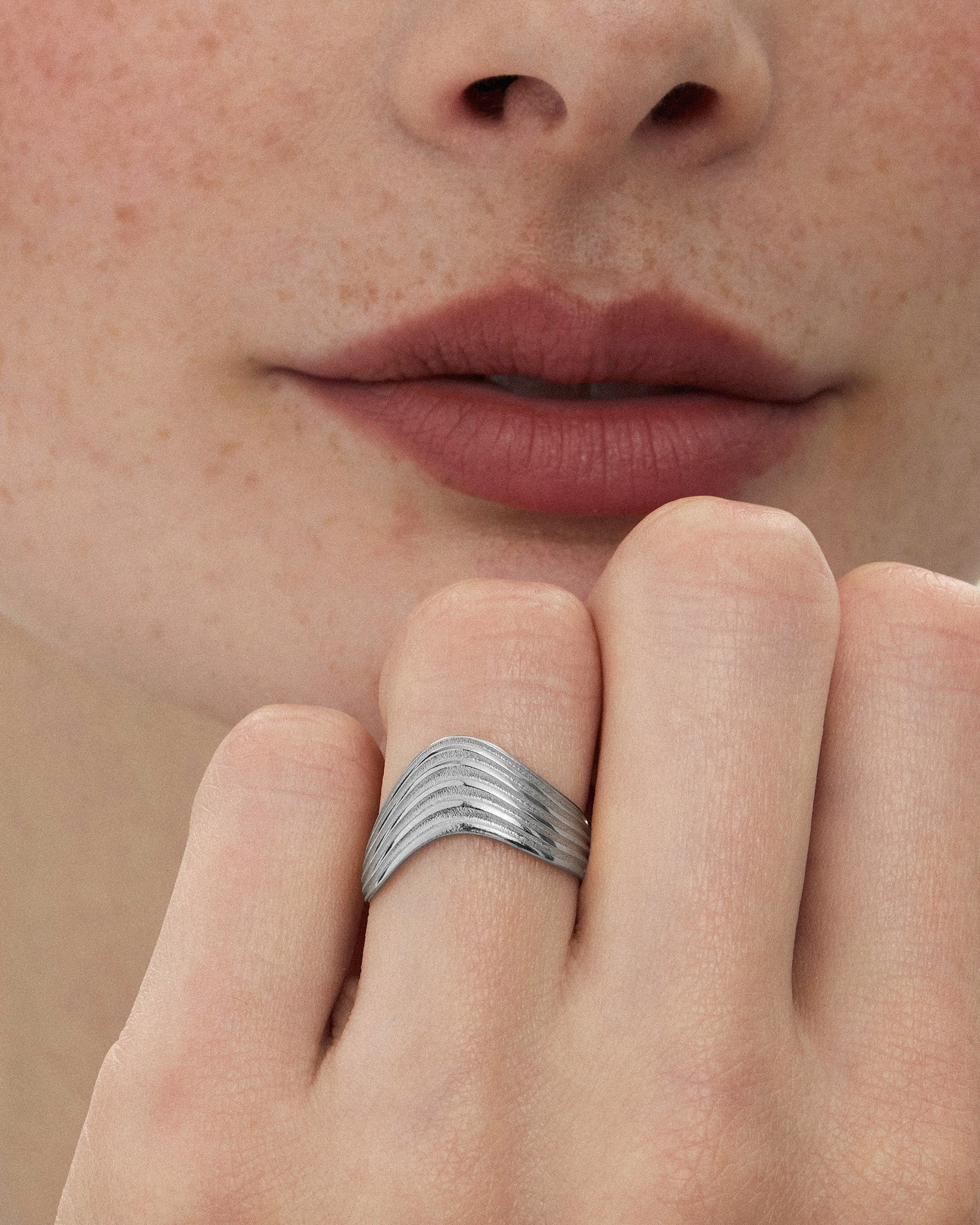 Close-up of a woman wearing the Kion III Ribbed Wave Ring in silver by ENEA