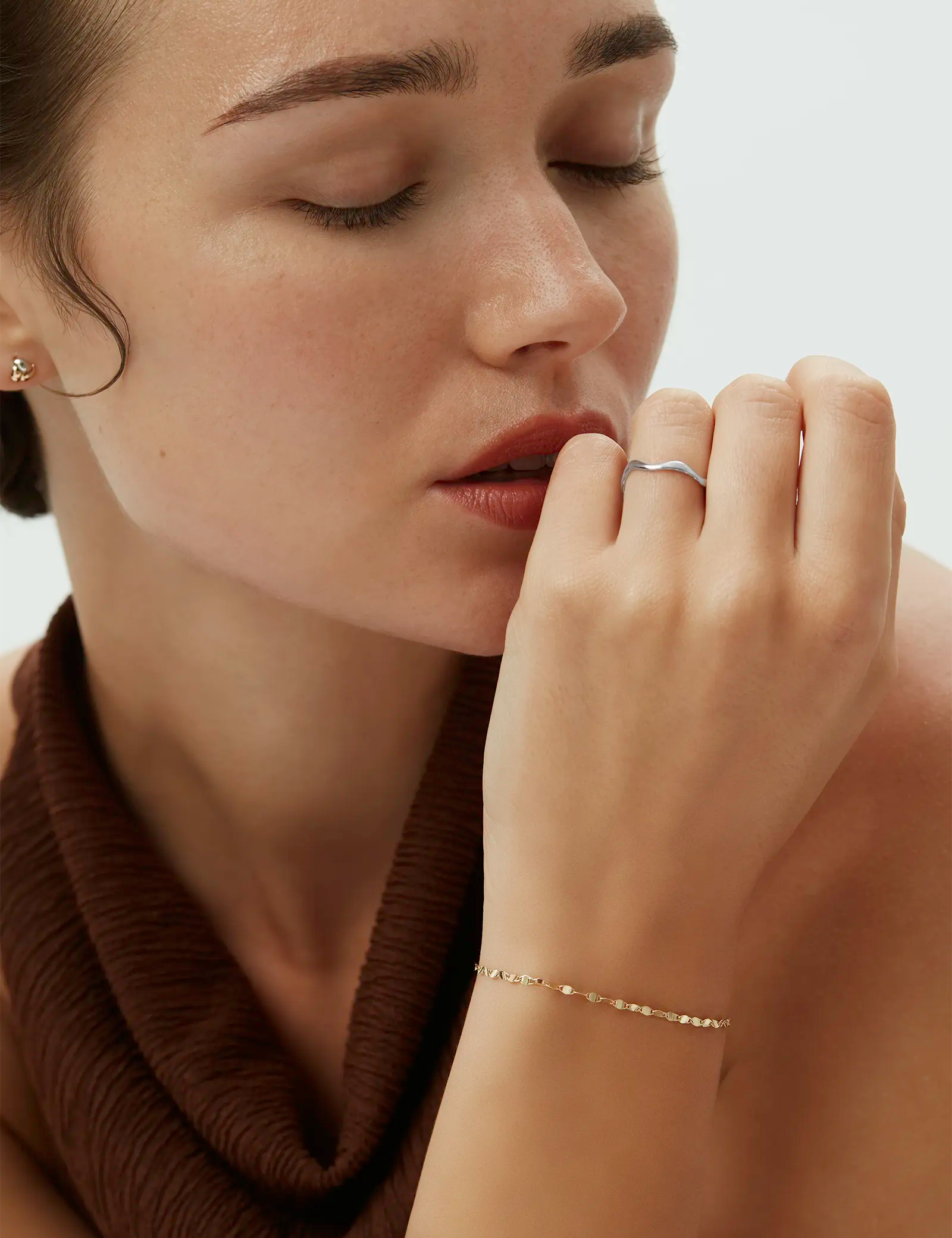 Model wearing the 14k white gold Kyma Organic Ring with a subtly wavy shape paired with a yellow gold bracelet. Enea Studio