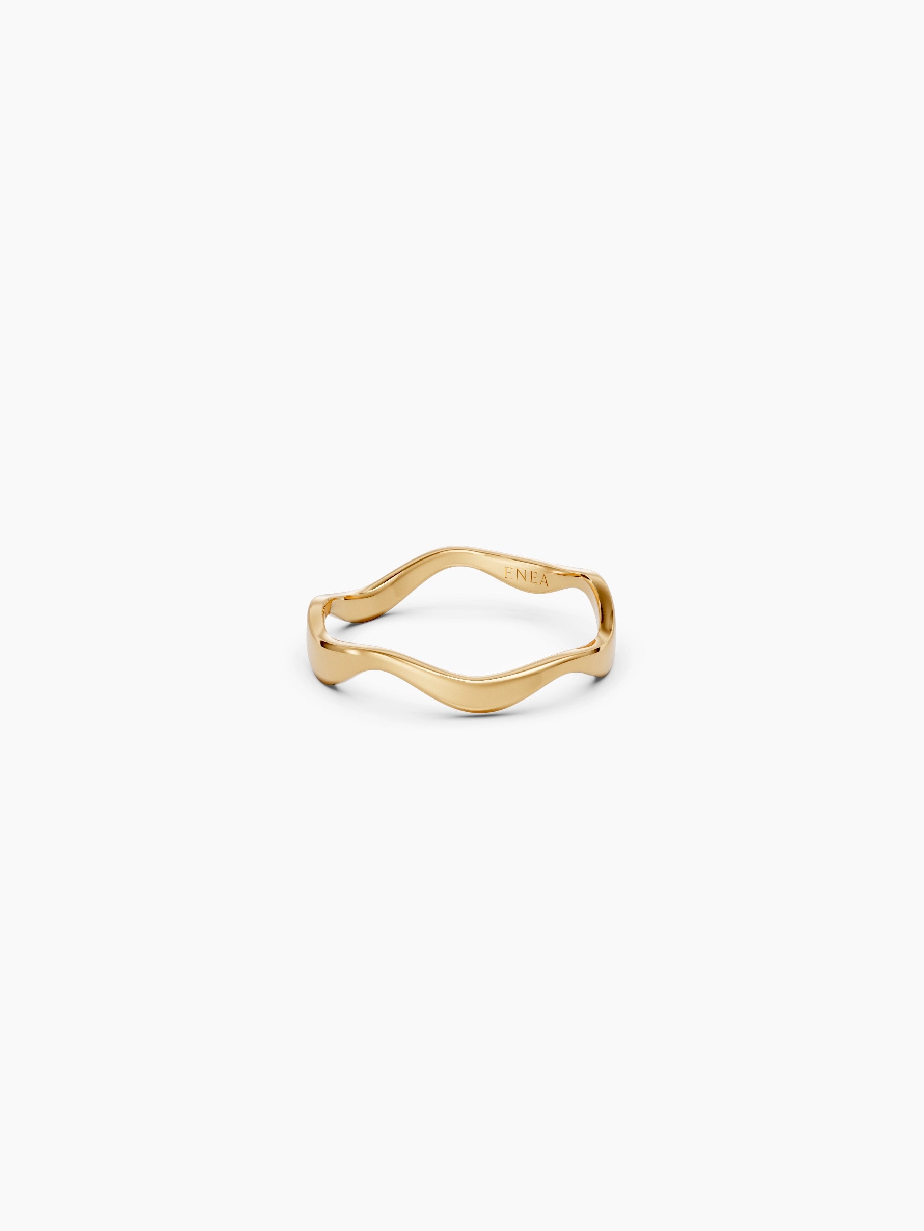 Front view of a yellow gold wavy band ring with a subtle curvy shape placed on a white background - Enea Studio
