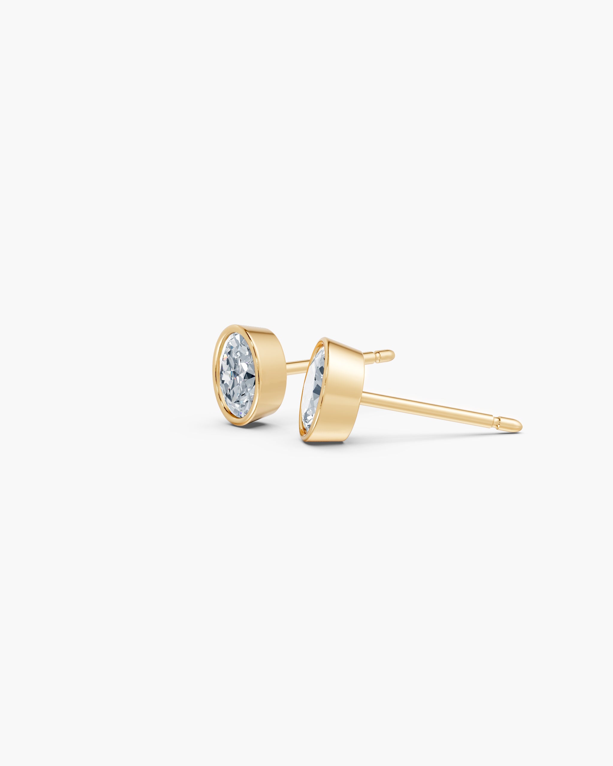 Side view of the oval bezel diamond stud in 14k yellow gold showing the low gold rim and post, ENEA Studio