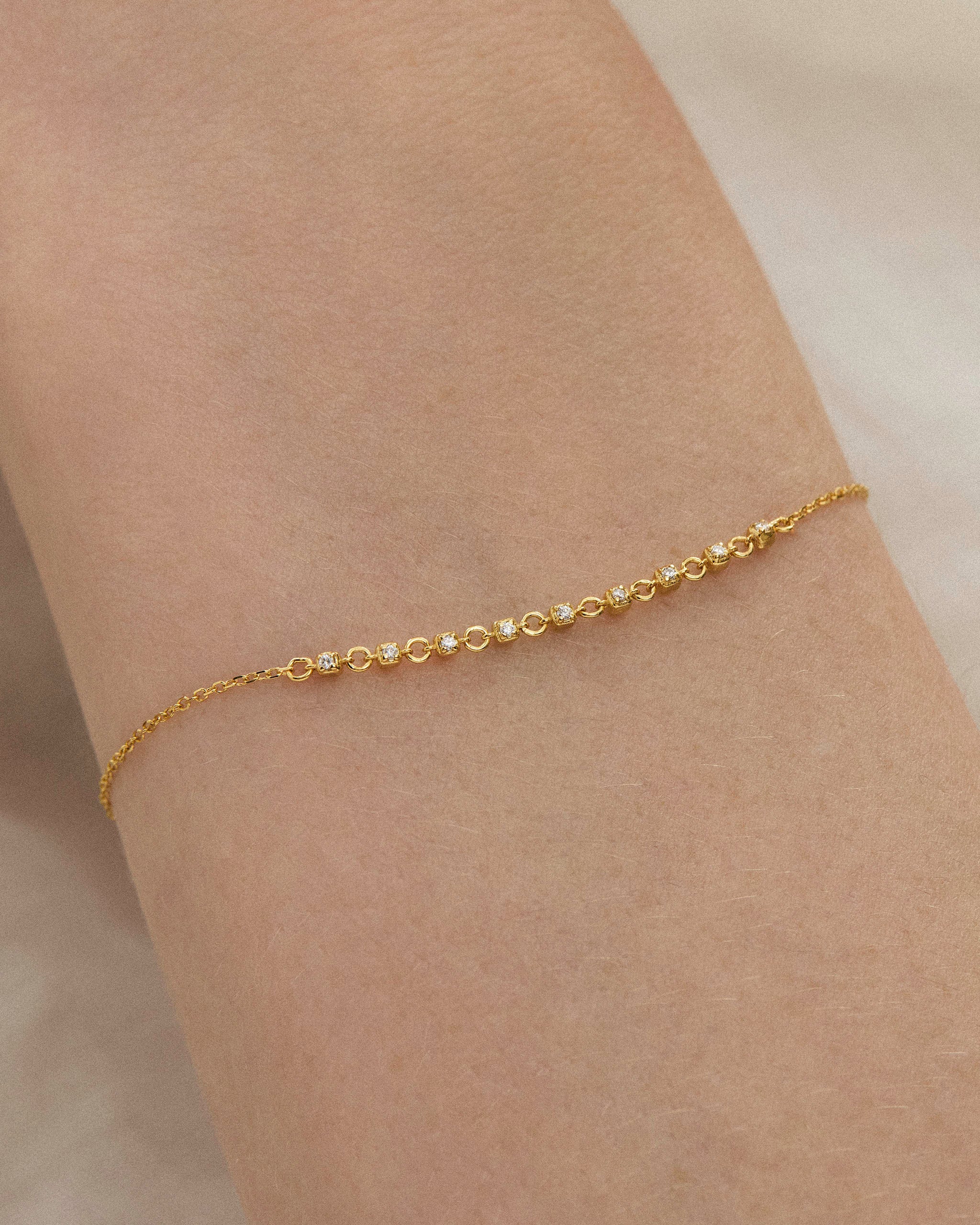 Close up of a delicate lab diamond tennis bracelet worn on a wrist