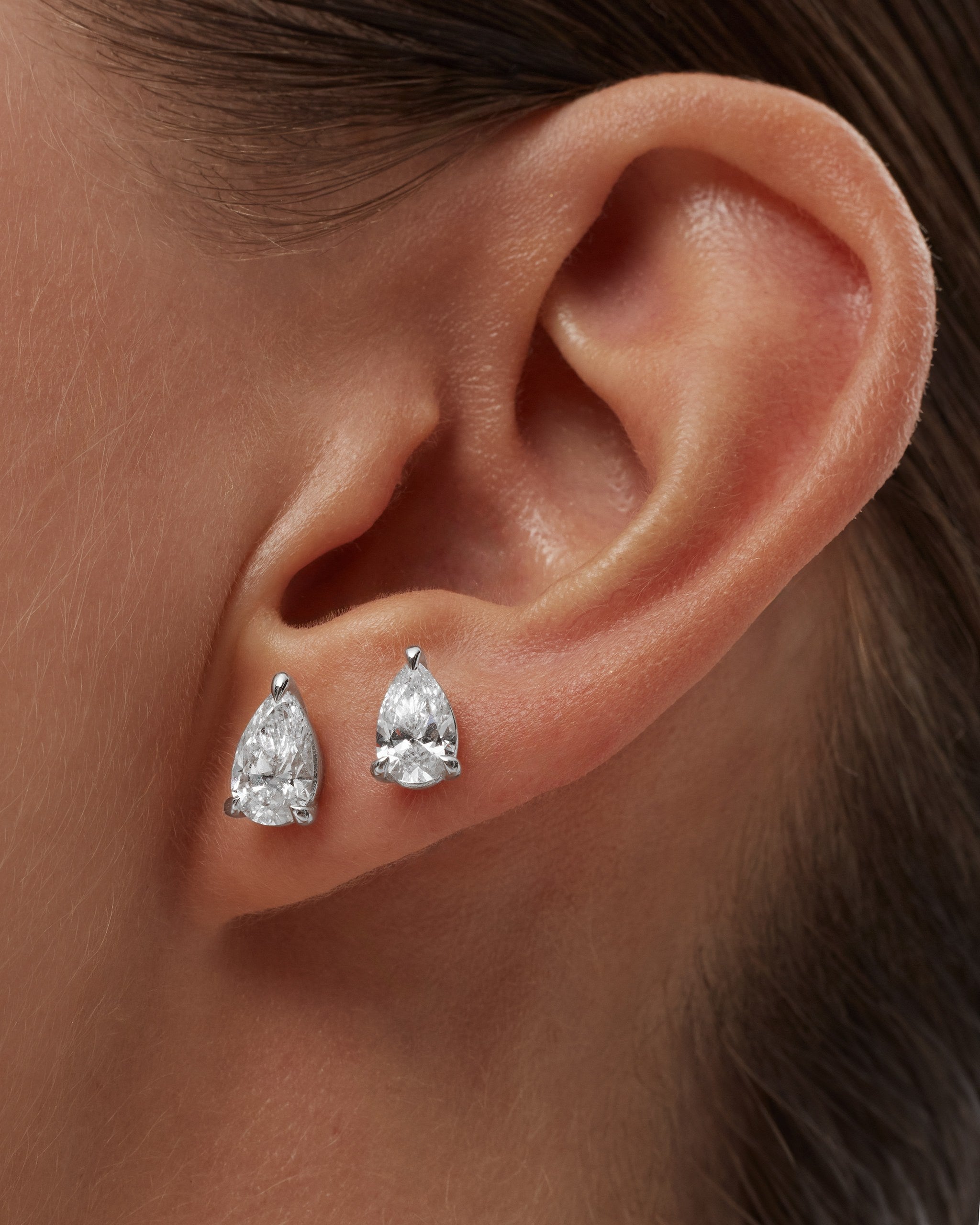 Model wearing pear lab diamond stud earrings in 14k white gold on the lobe and second piercing, ENEA Studio