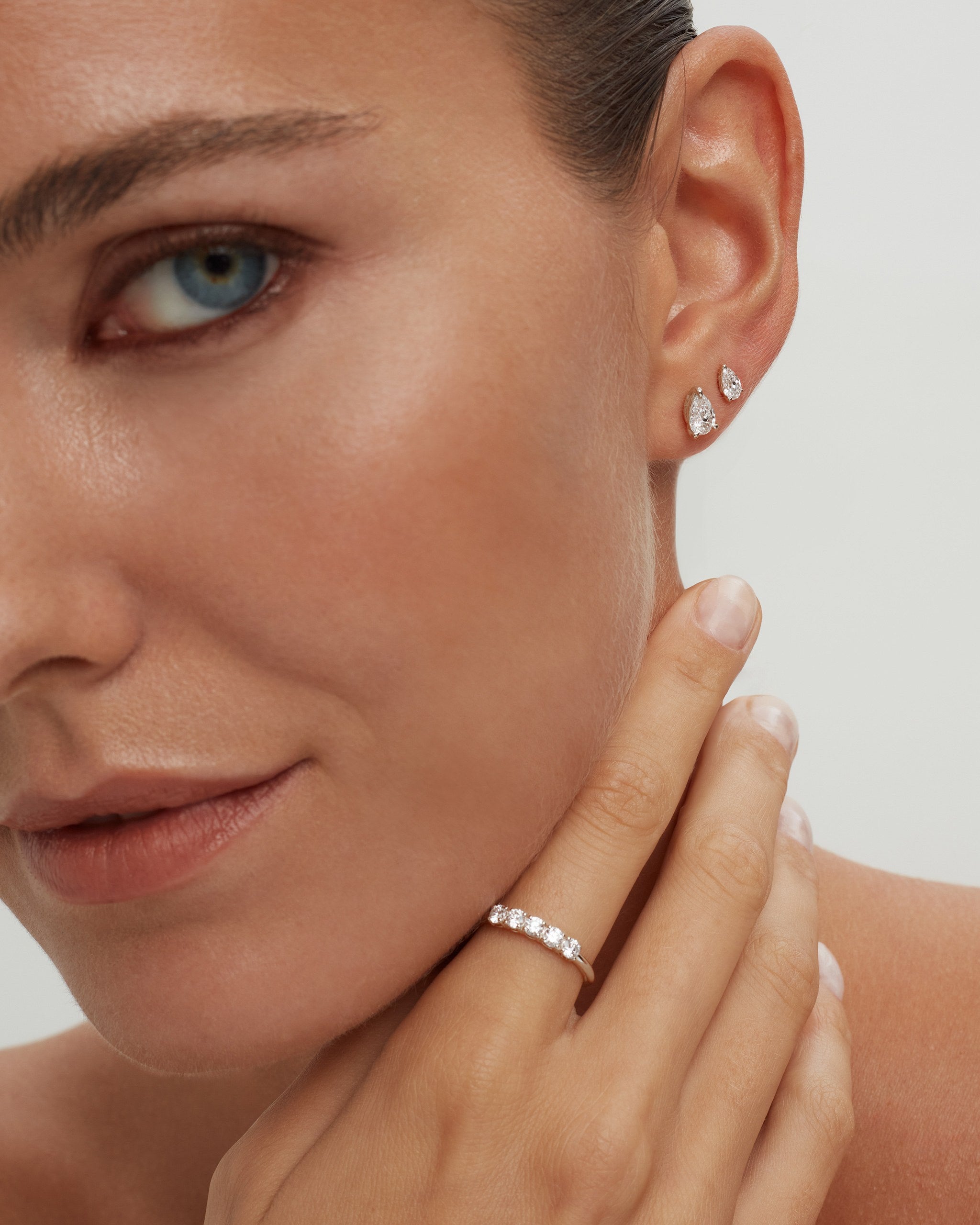 Pear lab diamond studs in 14k white gold worn point up with a diamond ring, ENEA Studio