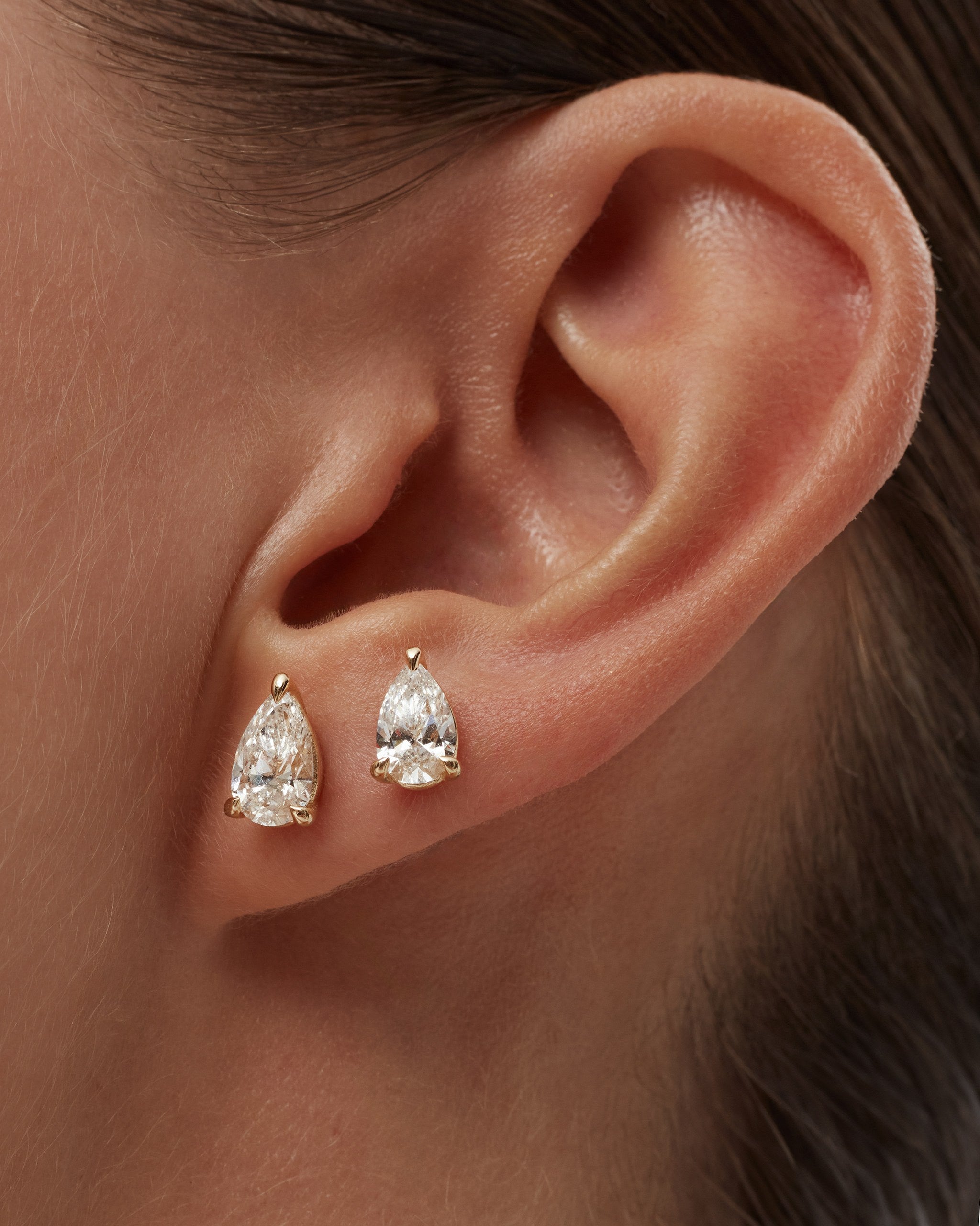 Model wearing pear lab diamond stud earrings in 14k yellow gold on the lobe and second piercing, ENEA Studio