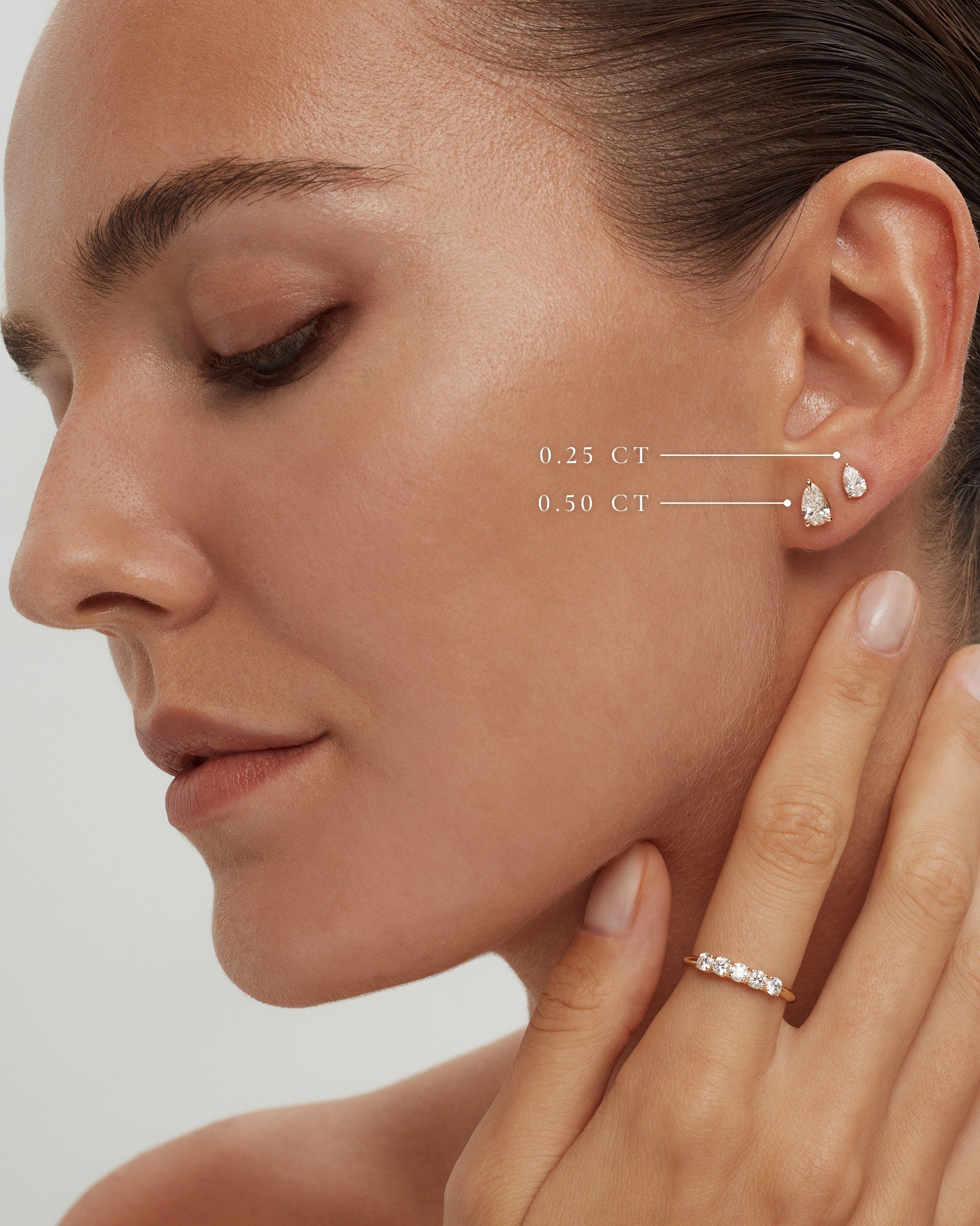 Model wearing pear lab diamond studs in 14k yellow gold, 0.50 ct and 0.25 ct each, labelled, ENEA Studio