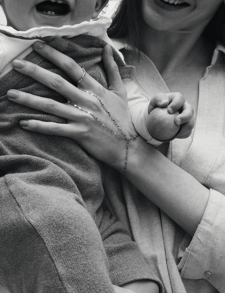 Mother and child, hand wearing gold jewelry, ENEA Studio