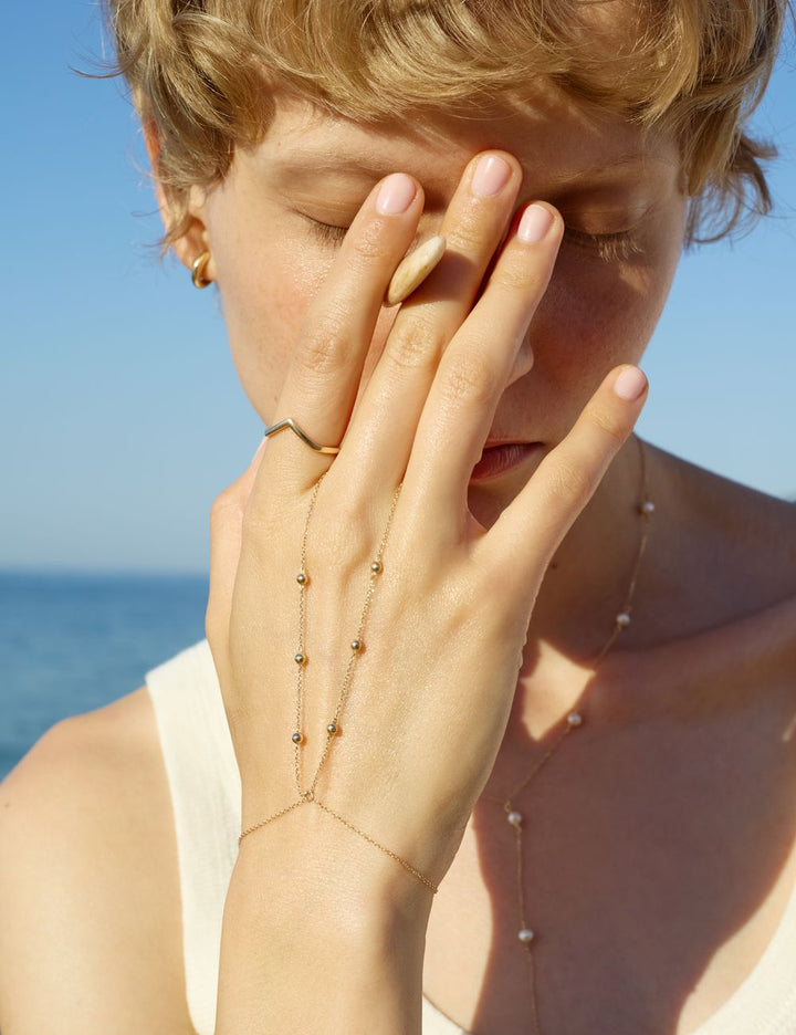 Gold hand chain by the sea, ENEA Studio