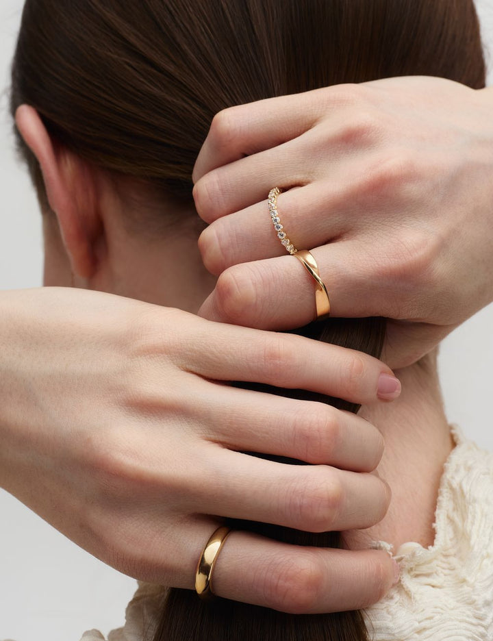 Hands in hair wearing stacked 14k gold rings, ENEA Studio