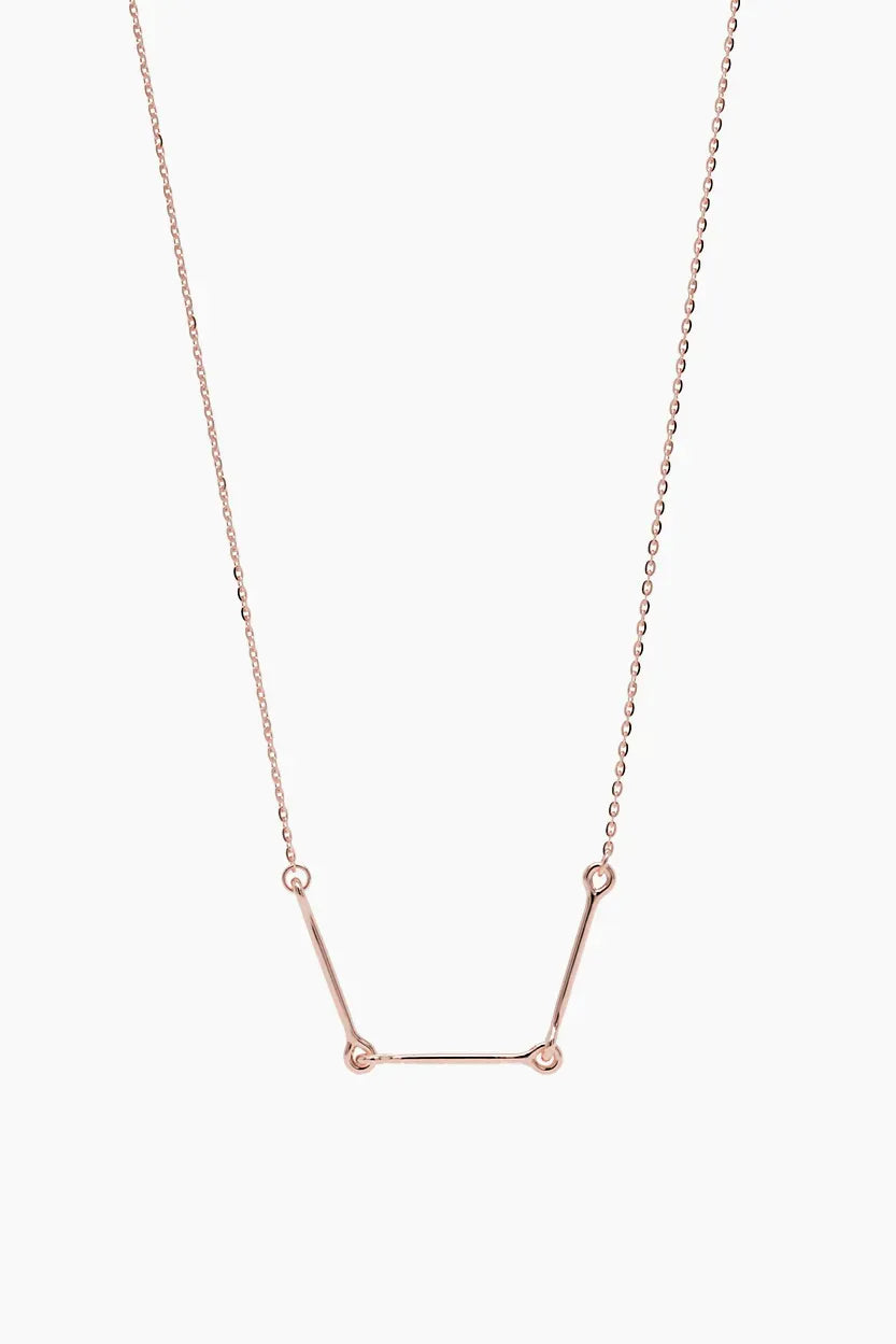Front-facing product image of the Iris Necklace in 14k rose gold, featuring three polished bars connected with rounded loops.