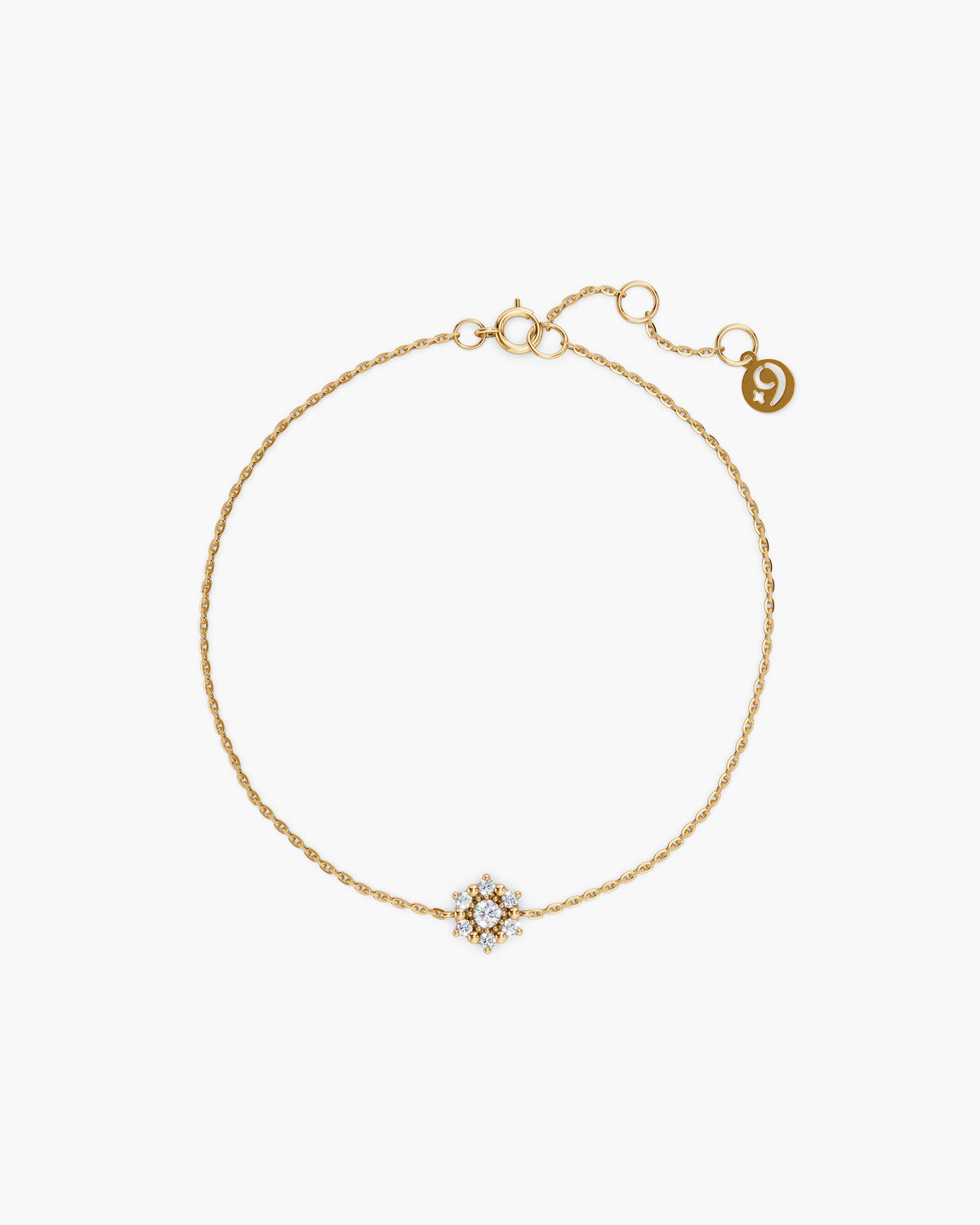 Selas Diamond Cluster Bracelet in 14k yellow gold, top view, a seven stone lab grown diamond cluster on a fine cable chain with an adjustable extender and ENEA tag, on an off-white surface. ENEA Studio