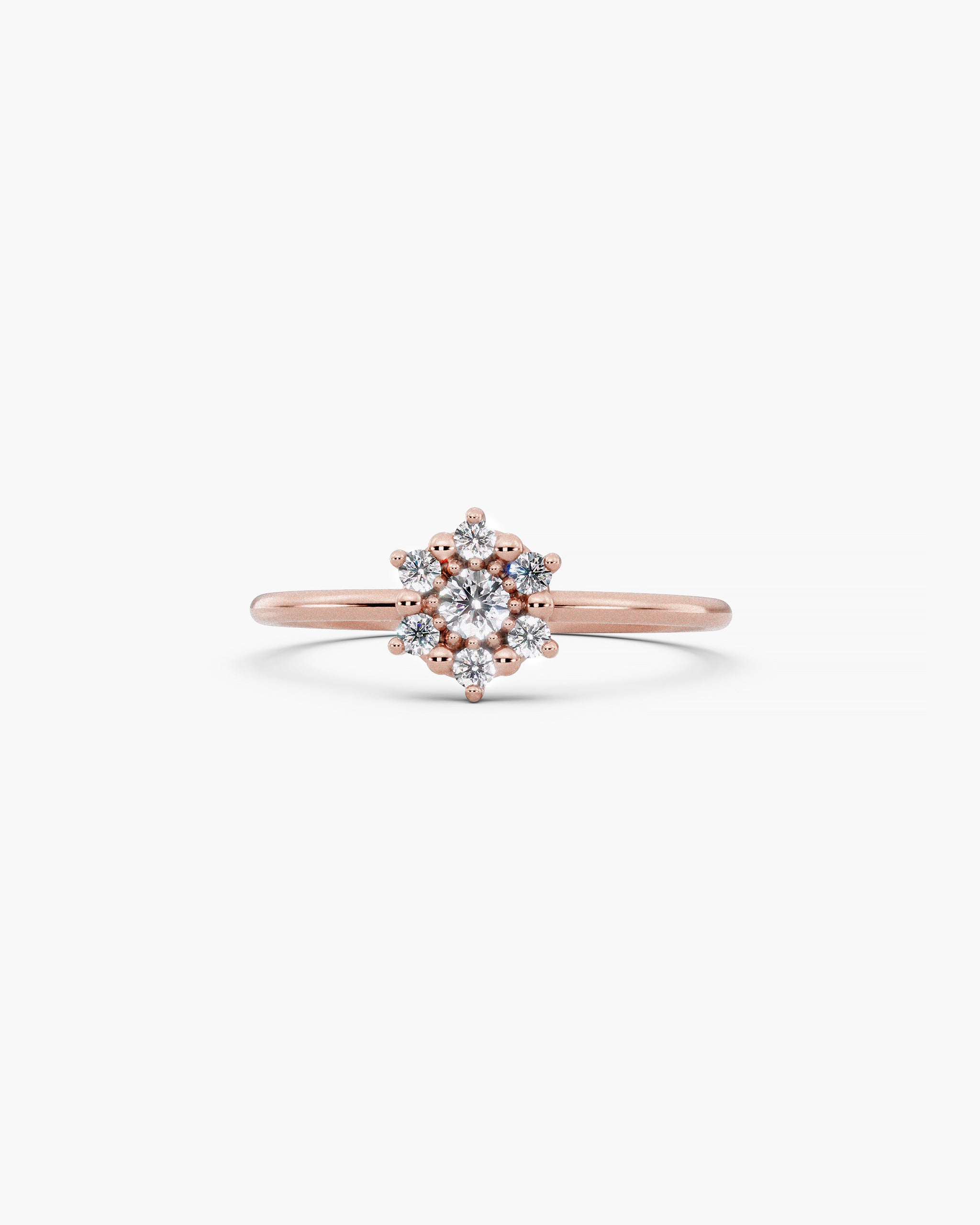 Selas Diamond Cluster Ring in 14k rose gold, front view, seven lab grown diamonds set as one burst of light on a fine 1.2mm band, on an off-white surface. ENEA Studio