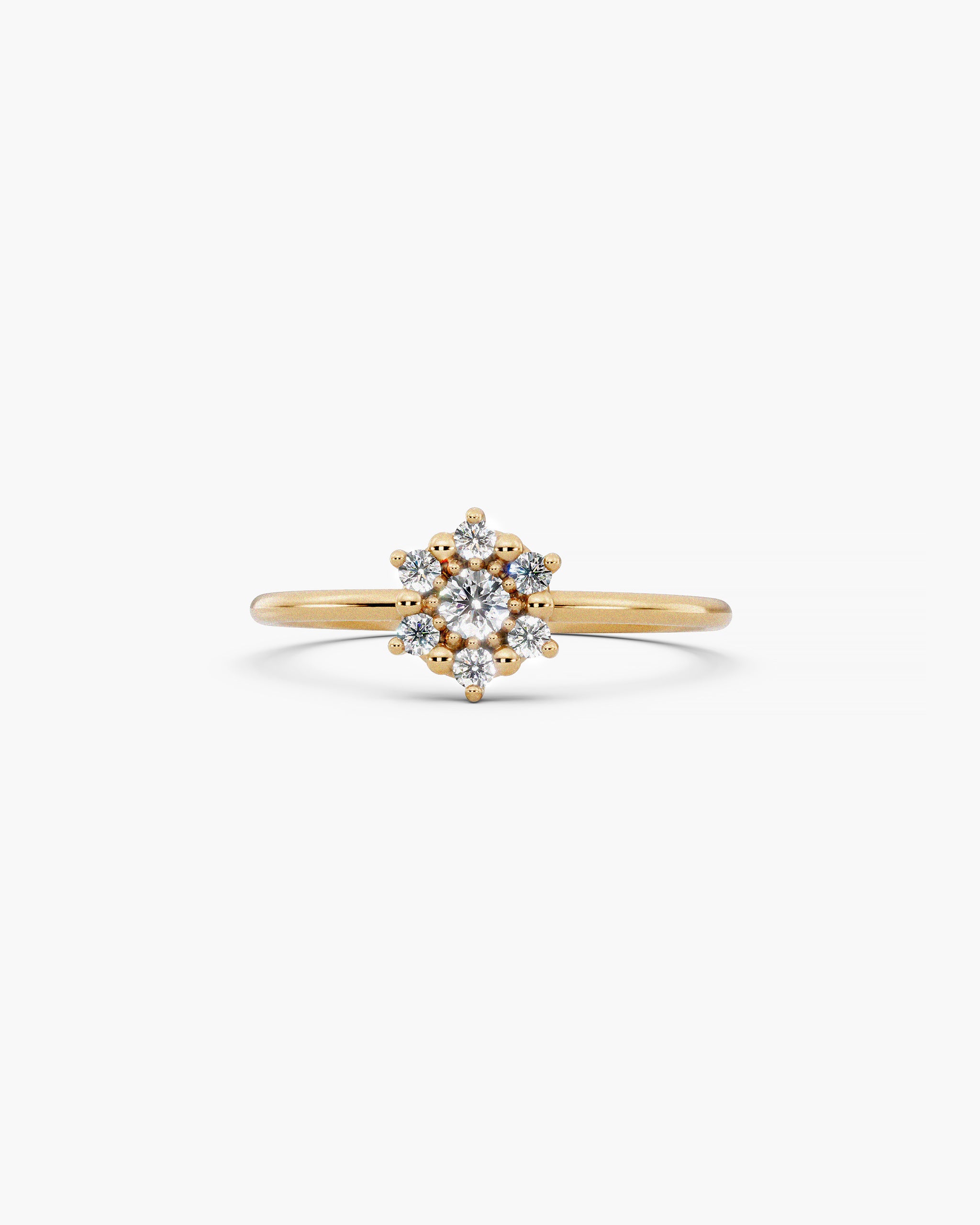 Selas Diamond Cluster Ring in 14k yellow gold, front view, seven lab grown diamonds set as one burst of light on a fine 1.2mm band, on an off-white surface. ENEA Studio